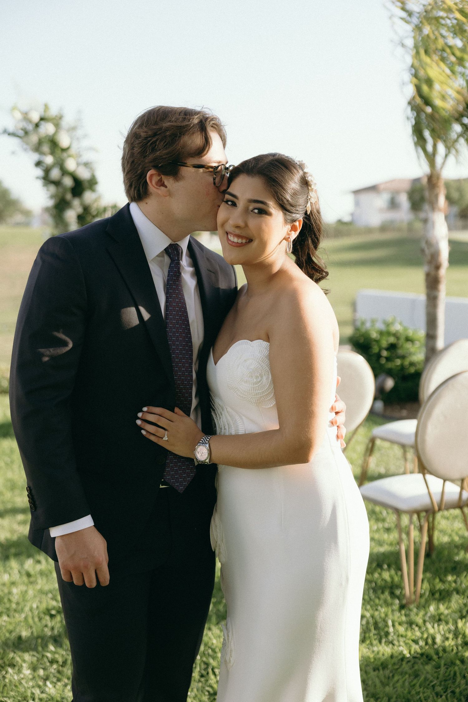 Couple sharing an intimate moment outdoors during a formal event.