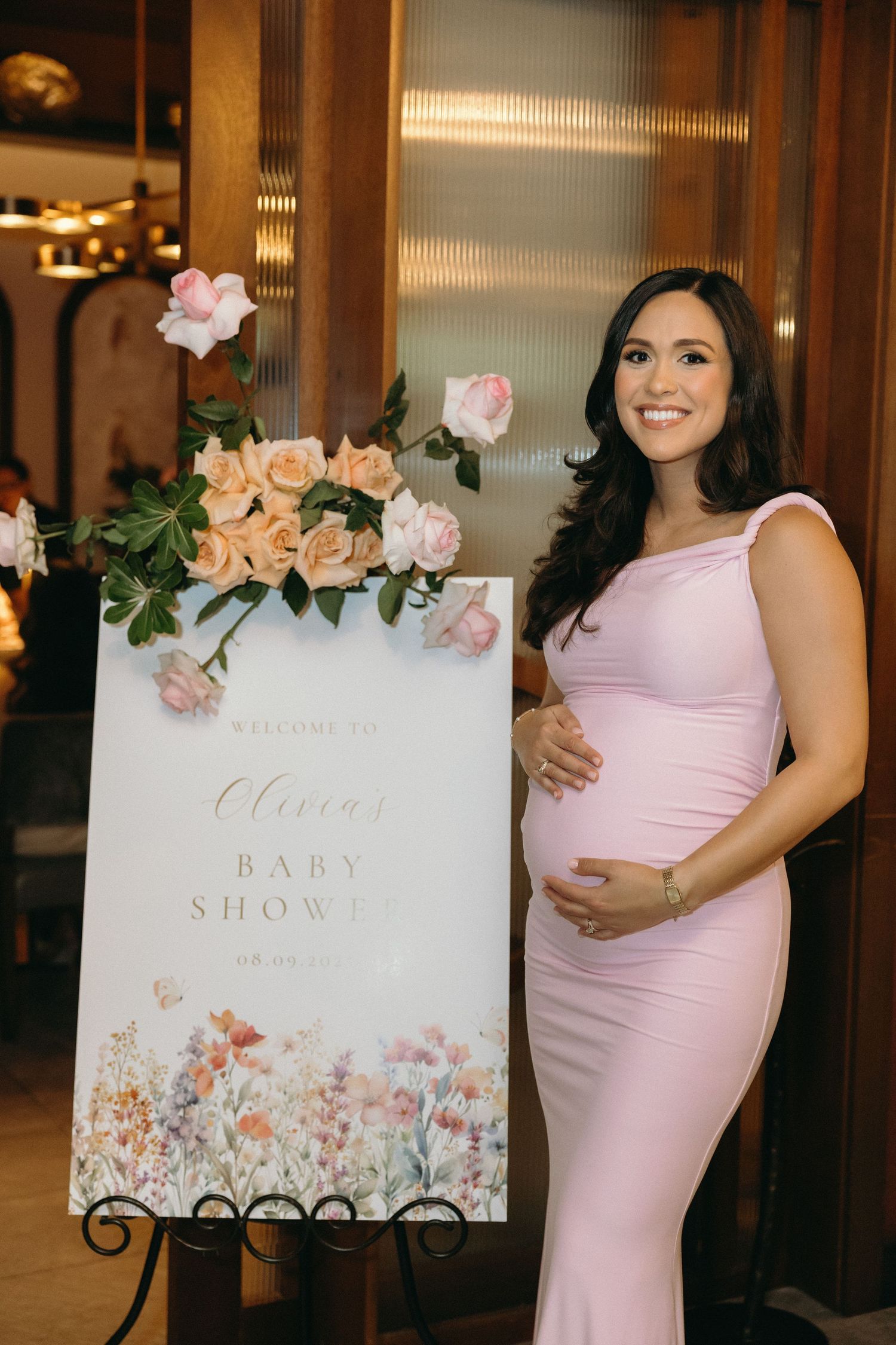 Baby shower decorations featuring floral signs and pink theme elements.