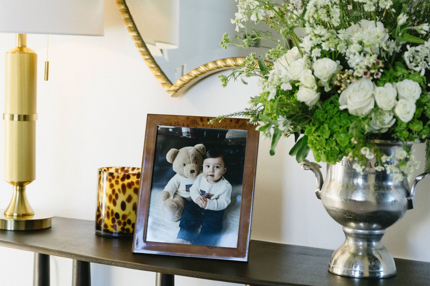 Elegant table display with white floral arrangements and gold candlesticks.