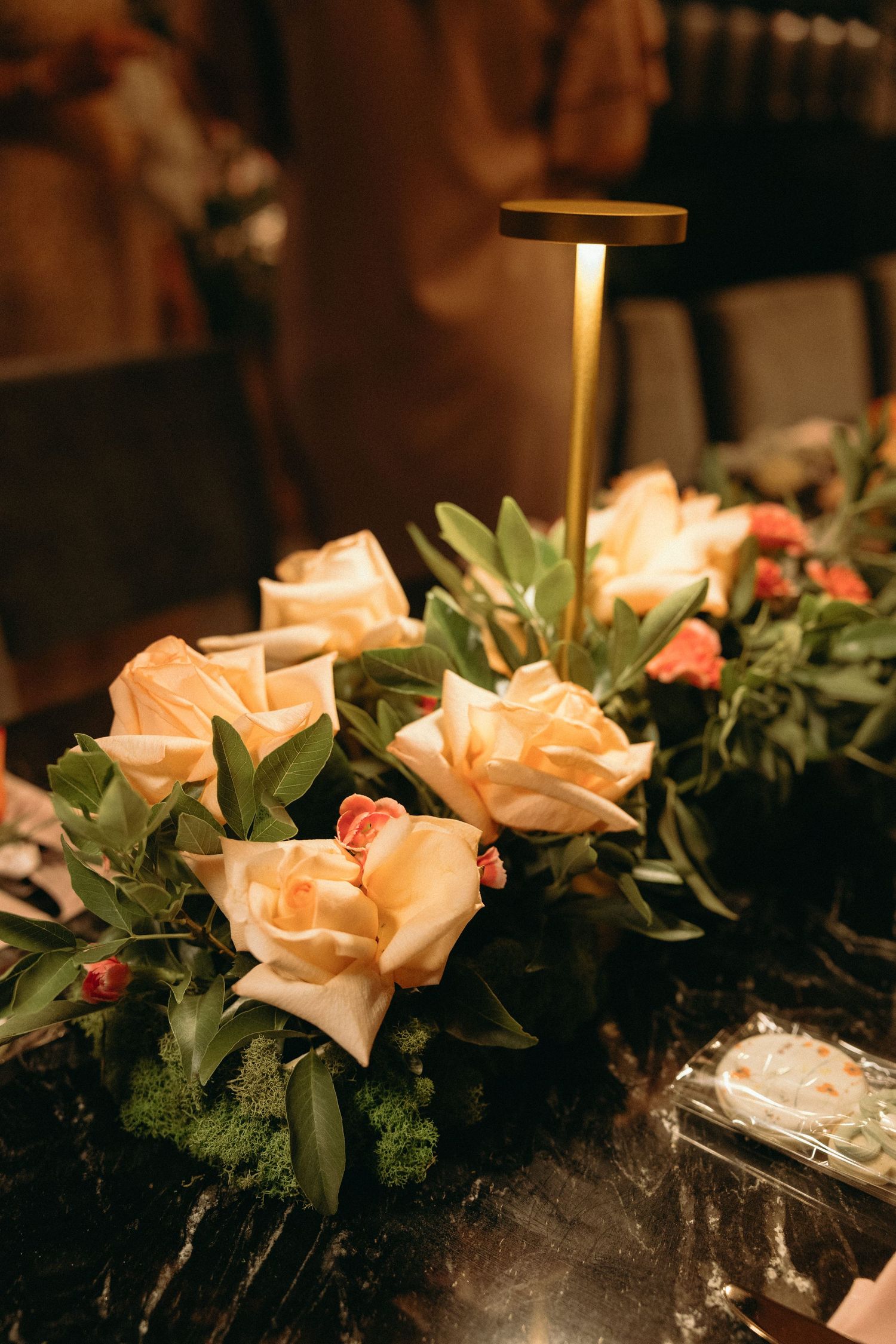 Peach roses and greenery arranged as decorative elements in warm lighting.