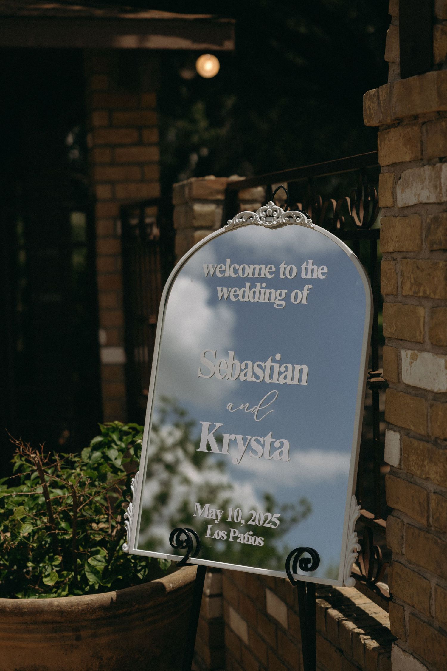 Elegant mirrored wedding welcome signs displayed against rustic brick walls.