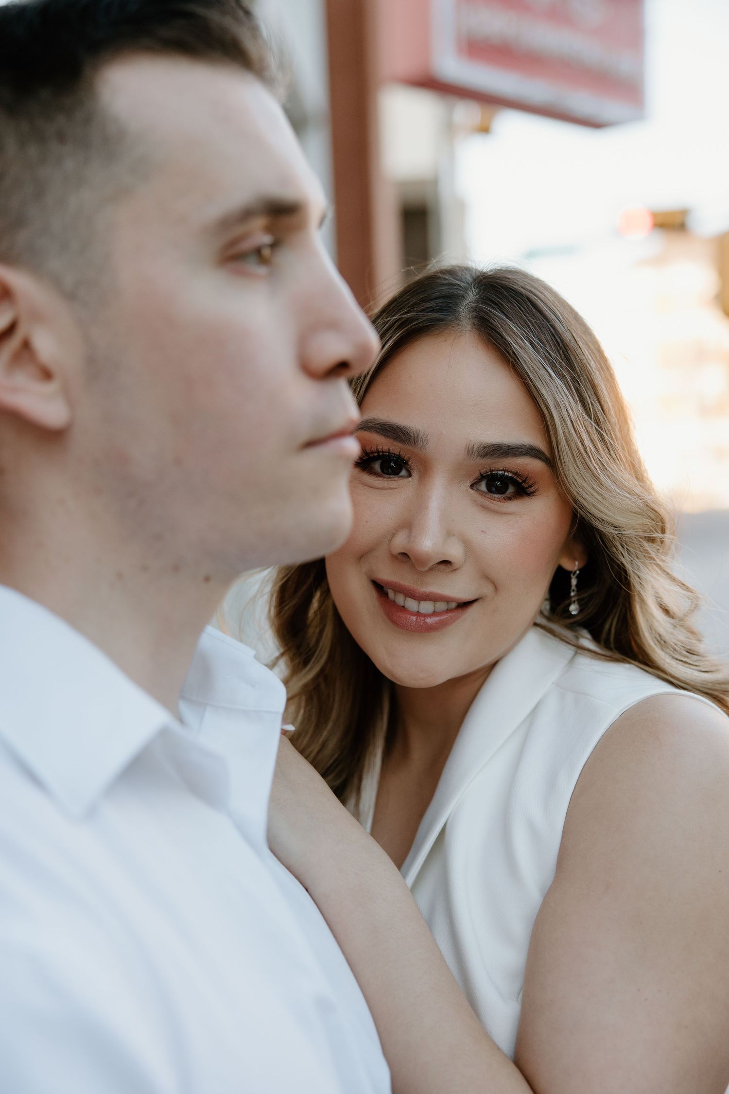 Close-up shot of a couple in white clothing gazing at each other with affection.