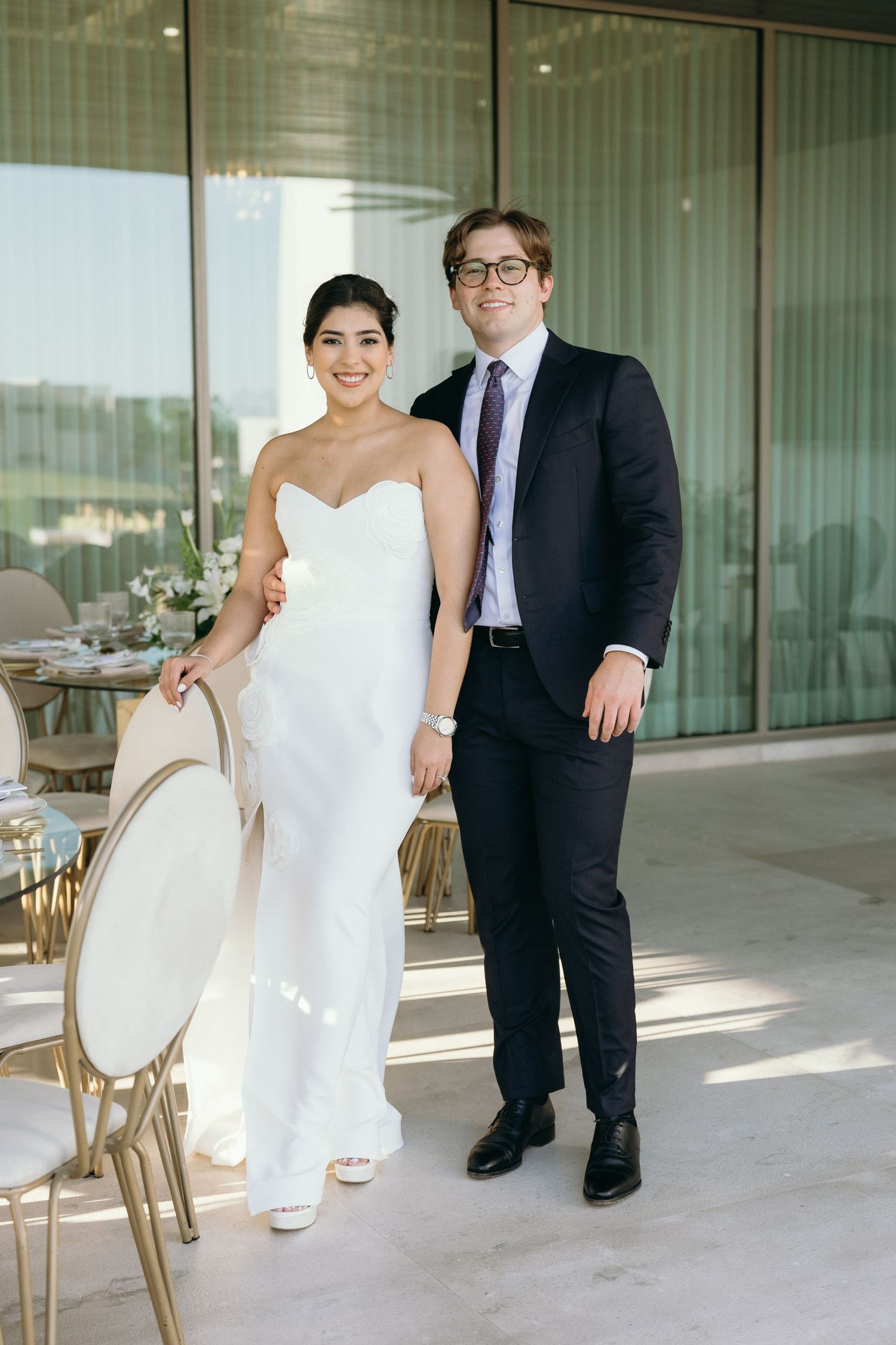 Couple posing together in formal wear on an outdoor terrace.