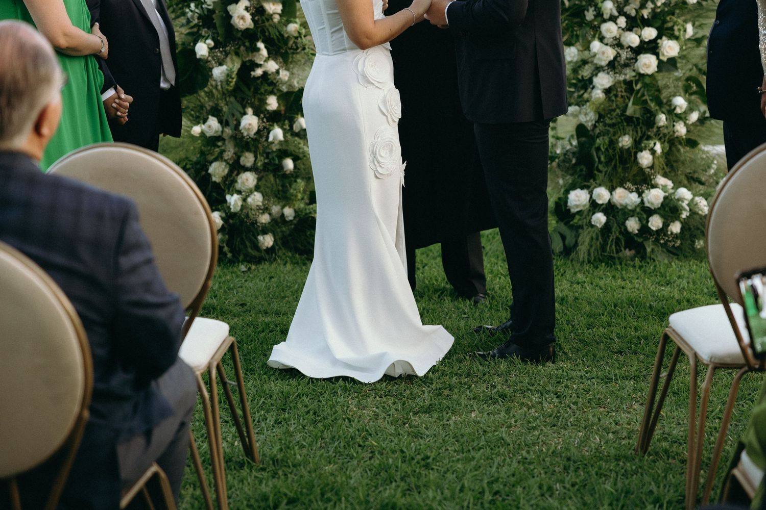 Wedding ceremony setup with chairs and floral decorations in an outdoor garden setting.