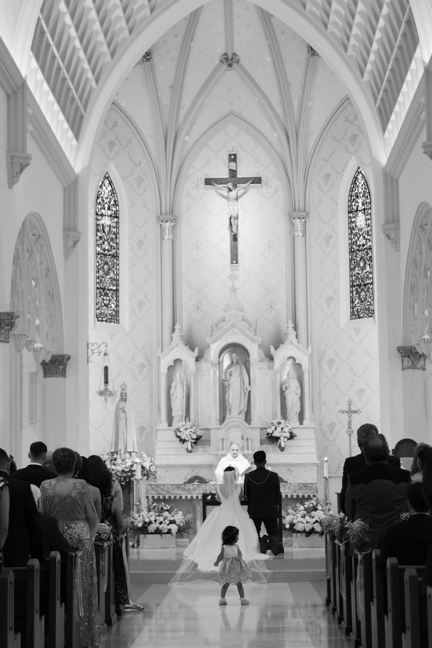 Black and white photo of wedding ceremony in a cathedral with Gothic architecture.