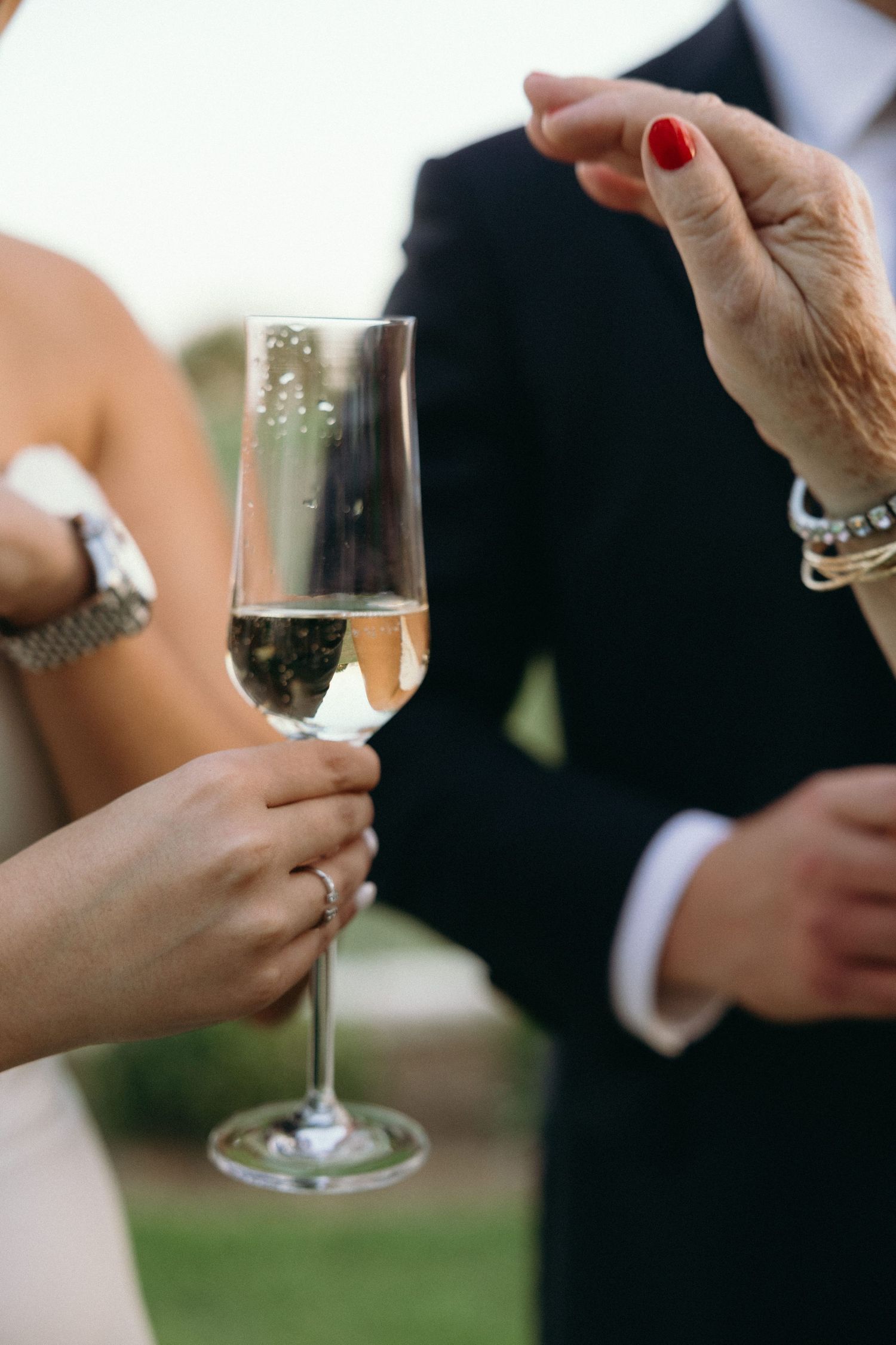 Close-up shots of champagne glasses being held during a wedding toast.