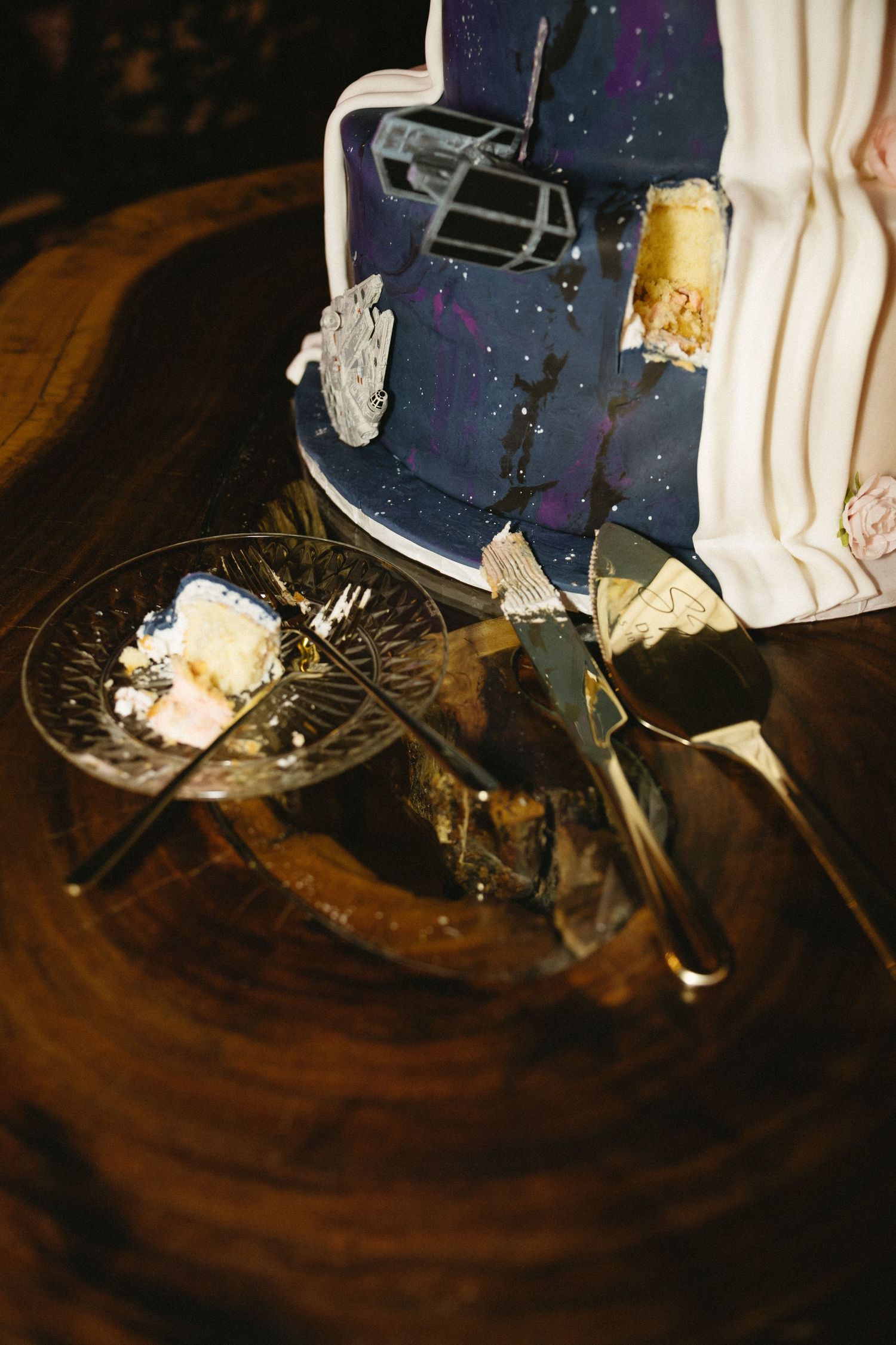 Close-up of a navy blue and white wedding cake with metallic decorative elements.