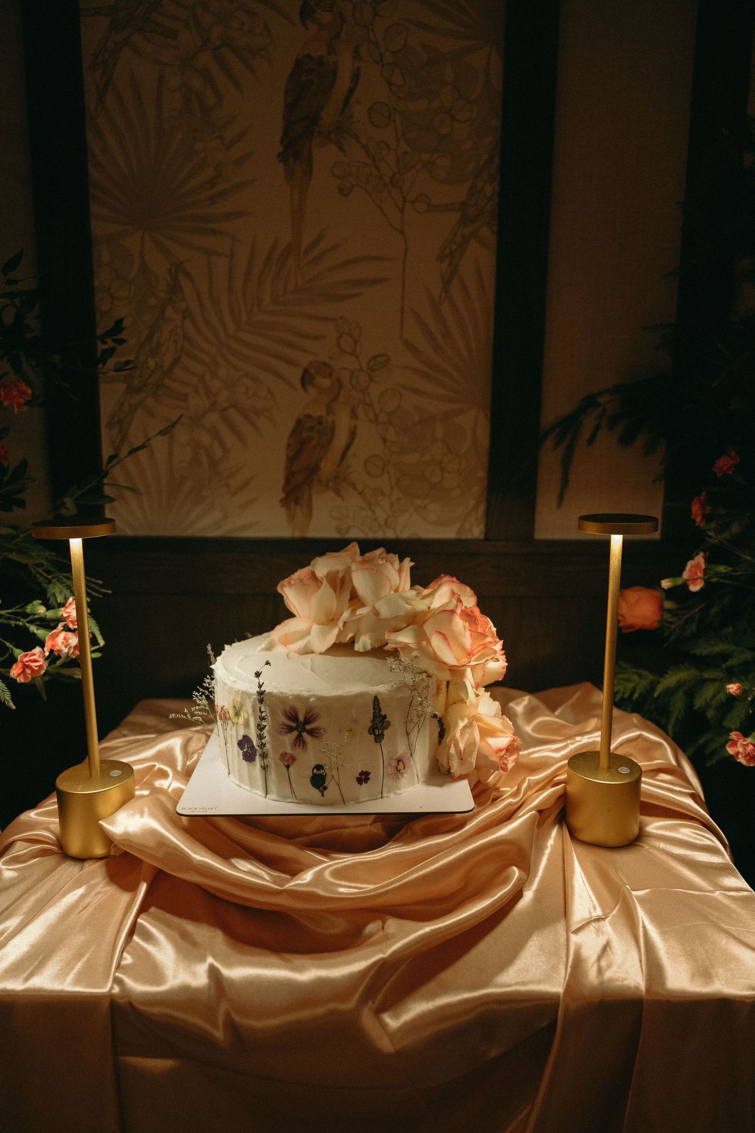 Elegant table setting with champagne-colored satin linens and floral decorations.