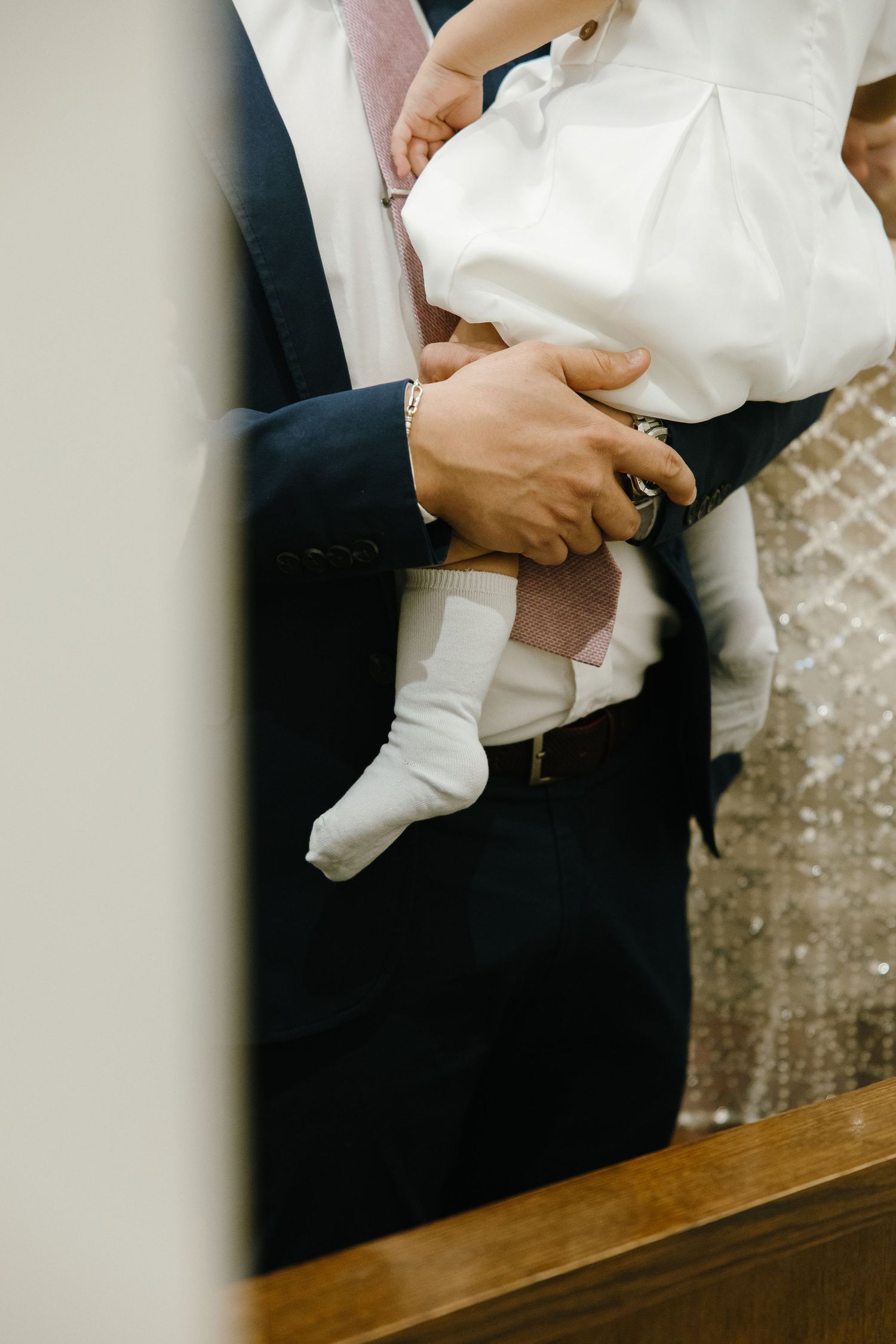 Close-up of formal attire and white fabric at an elegant event.