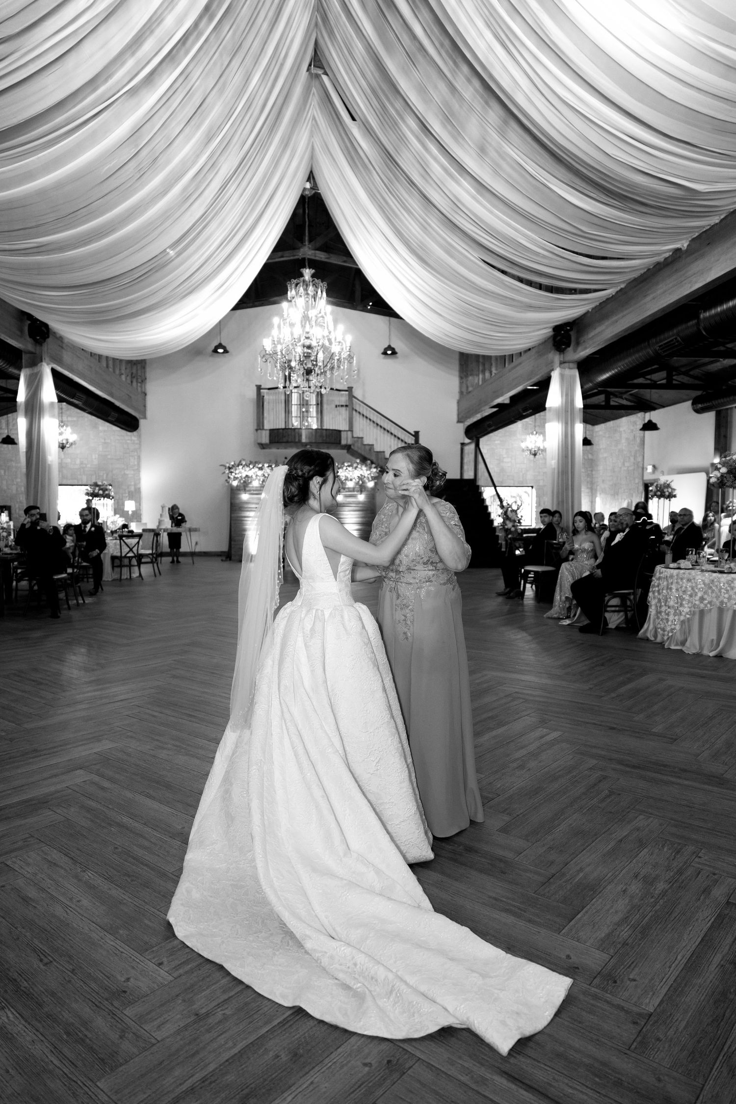 Elegant ballroom with draped white fabric ceiling and chandelier lighting.