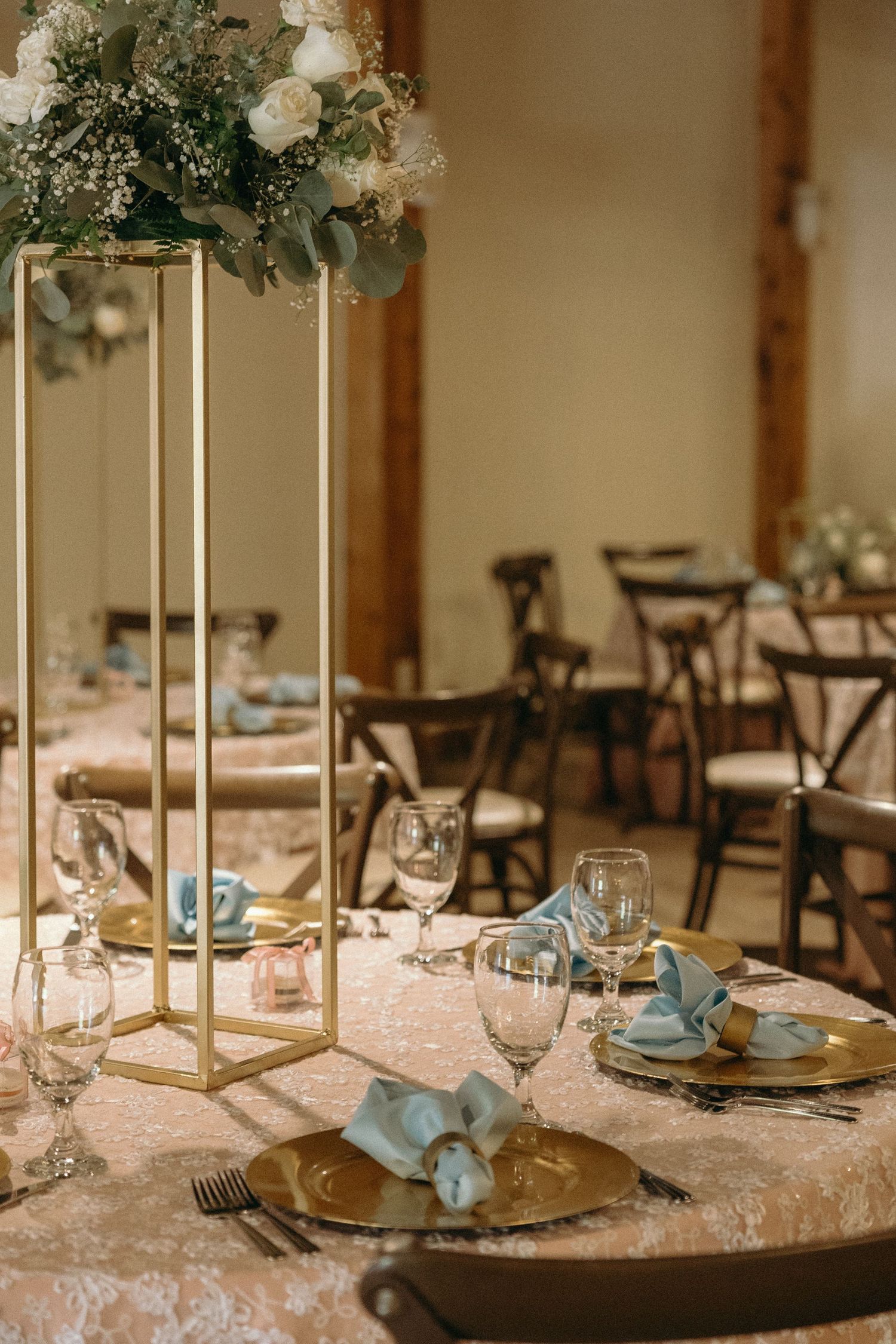 Wedding reception table settings with gold stands, white flowers, and turquoise accents.