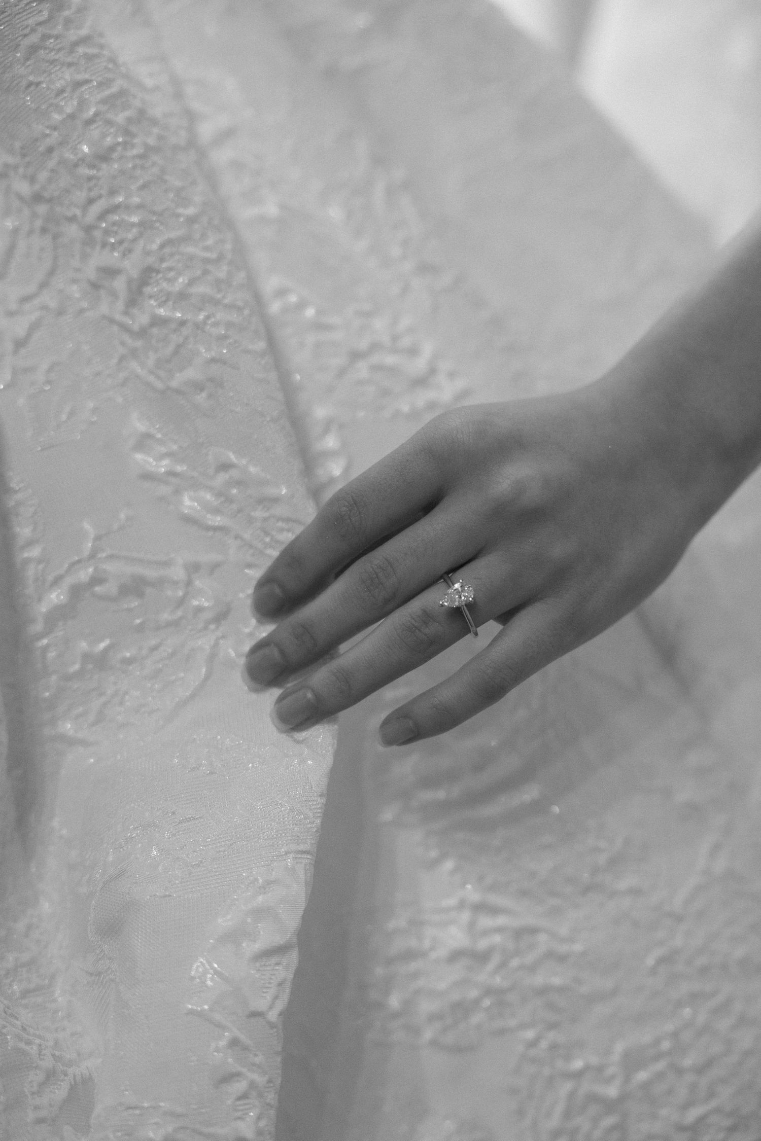 Close-up sequence showing a hand with an engagement ring against a textured white wall.