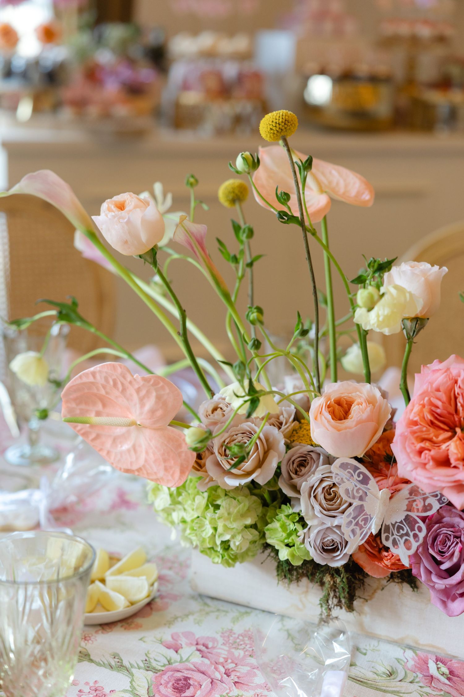 Delicate pink and white floral centerpiece arrangement on dining table.