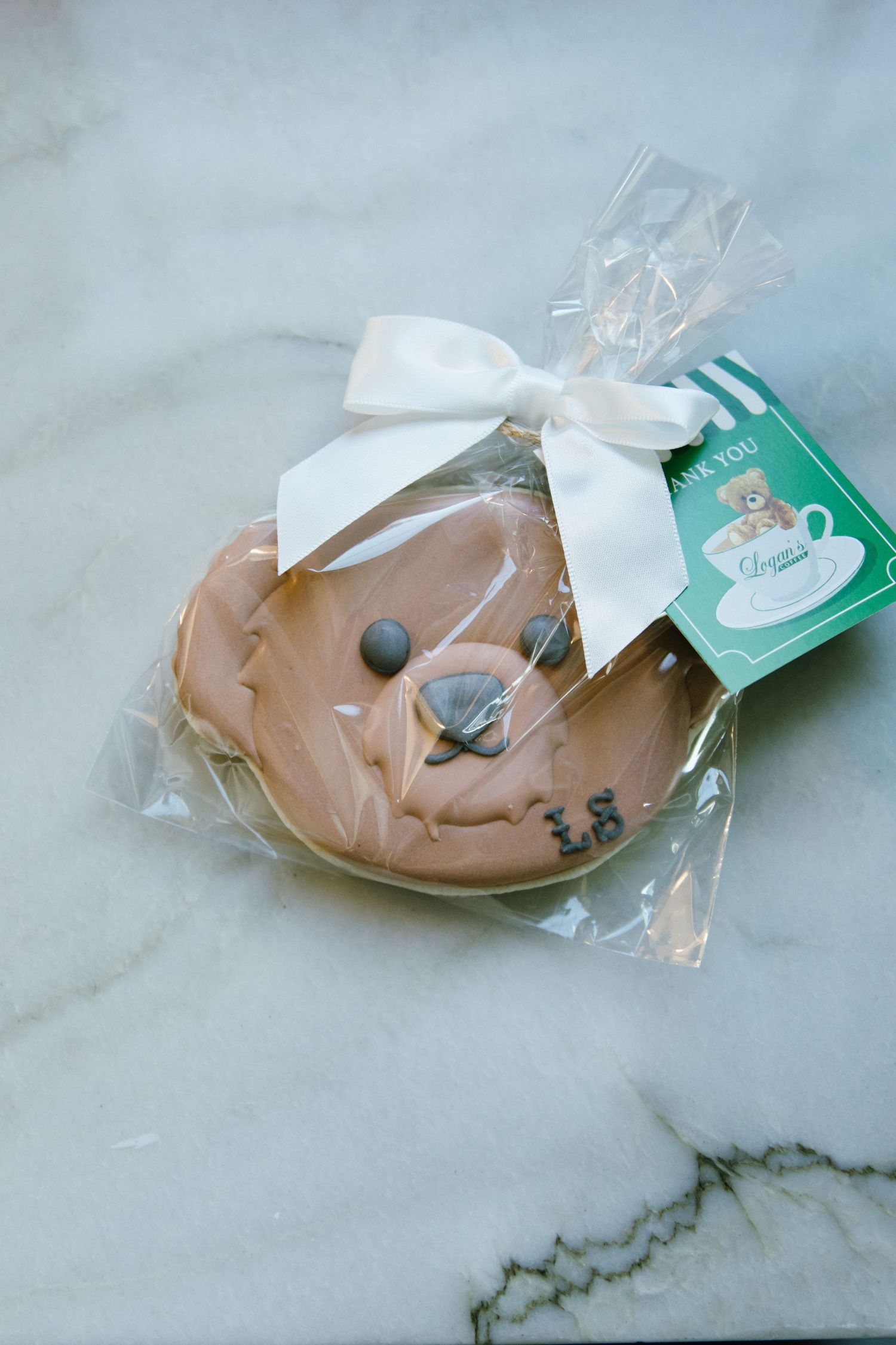 Packaged cookies with mint green branded tags on marble countertop.