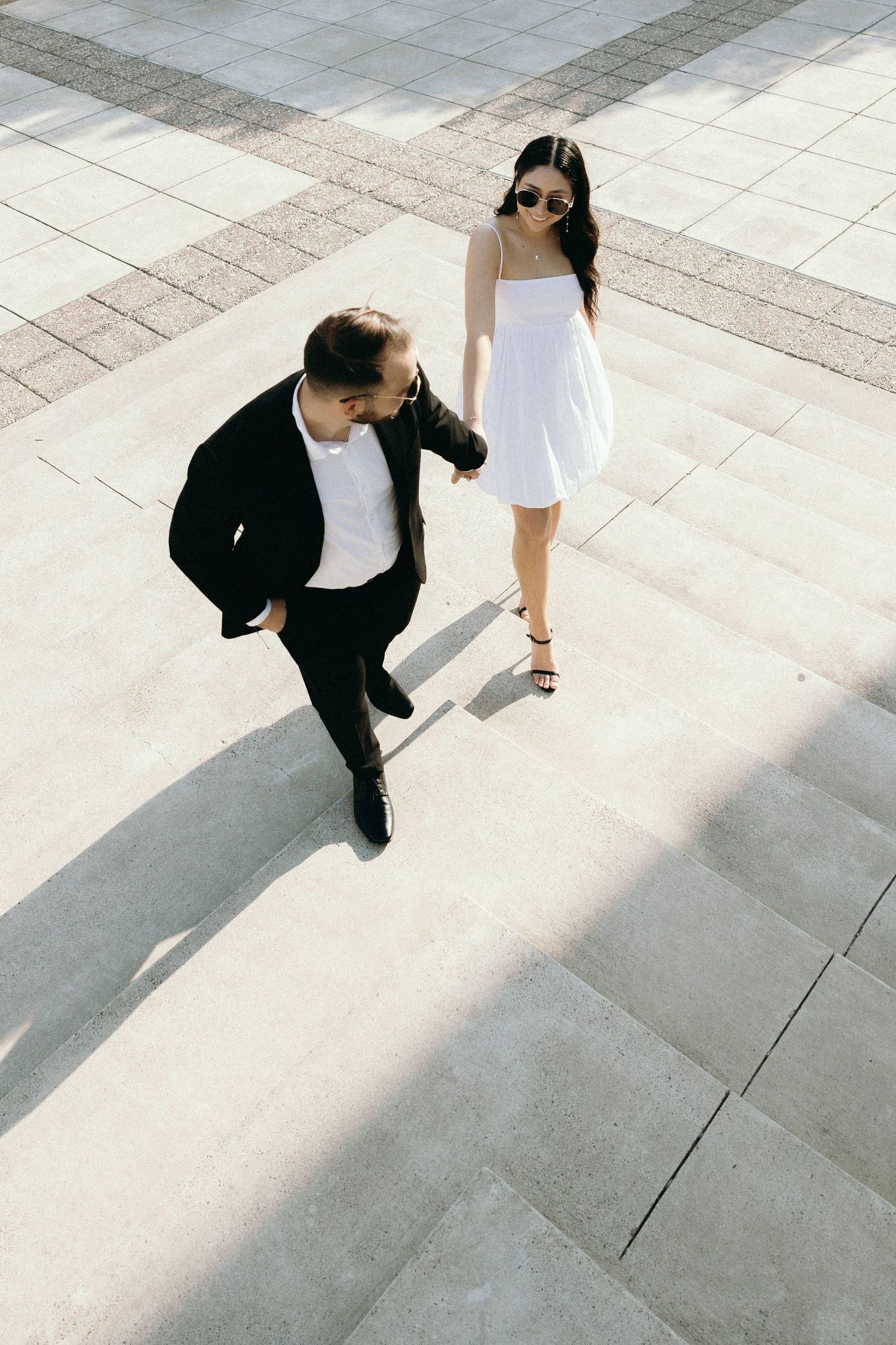 Artistic sequence of a couple in black and white on tiled ground.