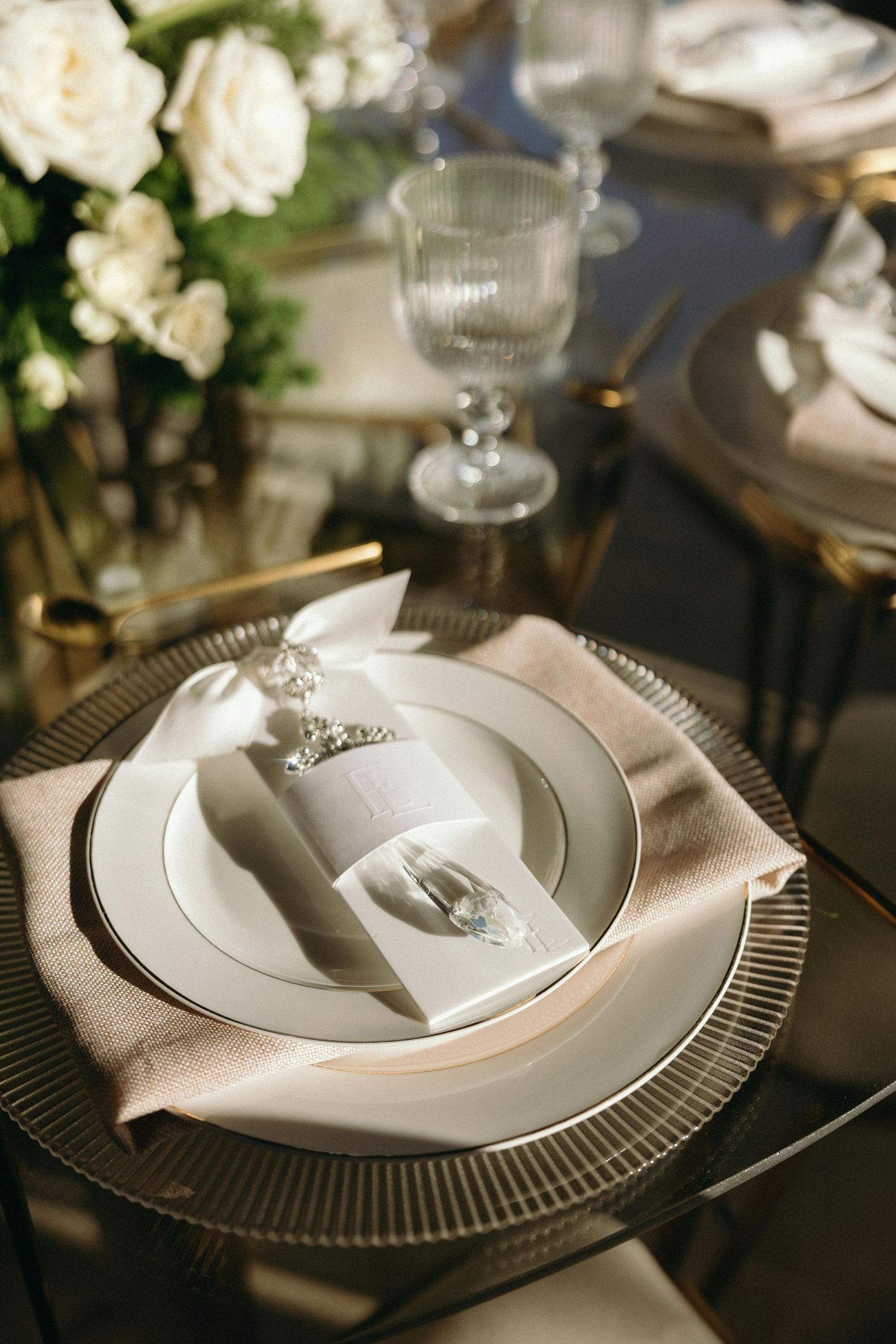 Formal table setting with silver charger plates and white linens at an upscale event.