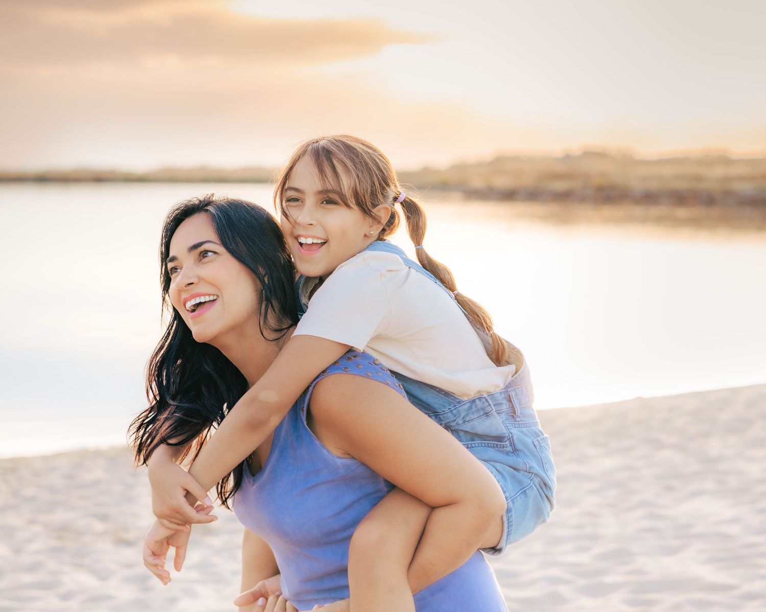mother giving daughter piggyback ride at beach sunset family photography St Albert