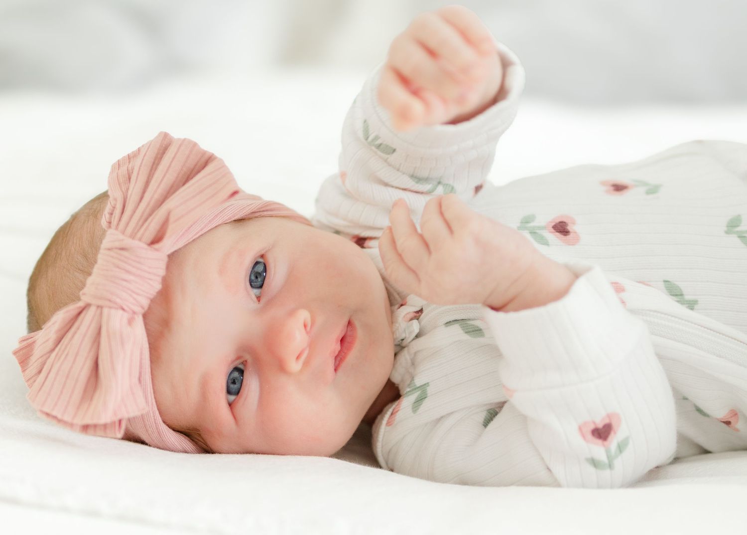 newborn baby girl wearing pink bow lying on blanket newborn photography St Albert photographer
