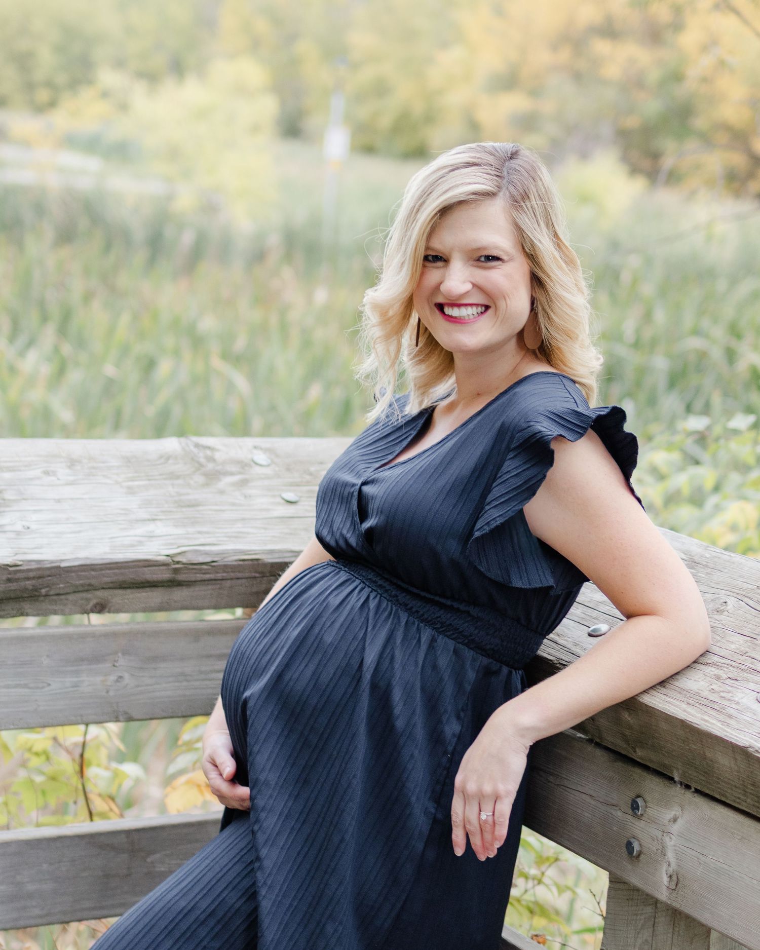 pregnant woman leaning on wooden fence outdoor maternity photography St Albert Alberta