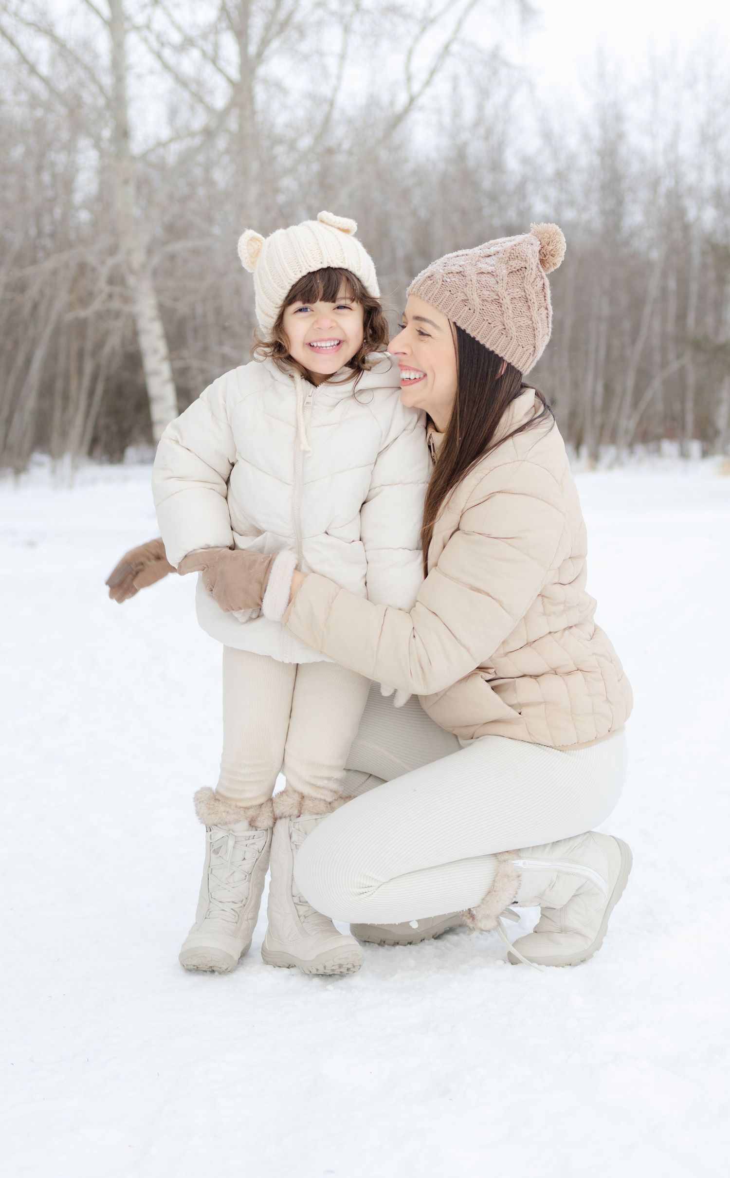 mother hugging daughter in snowy winter portrait session St Albert family photographer