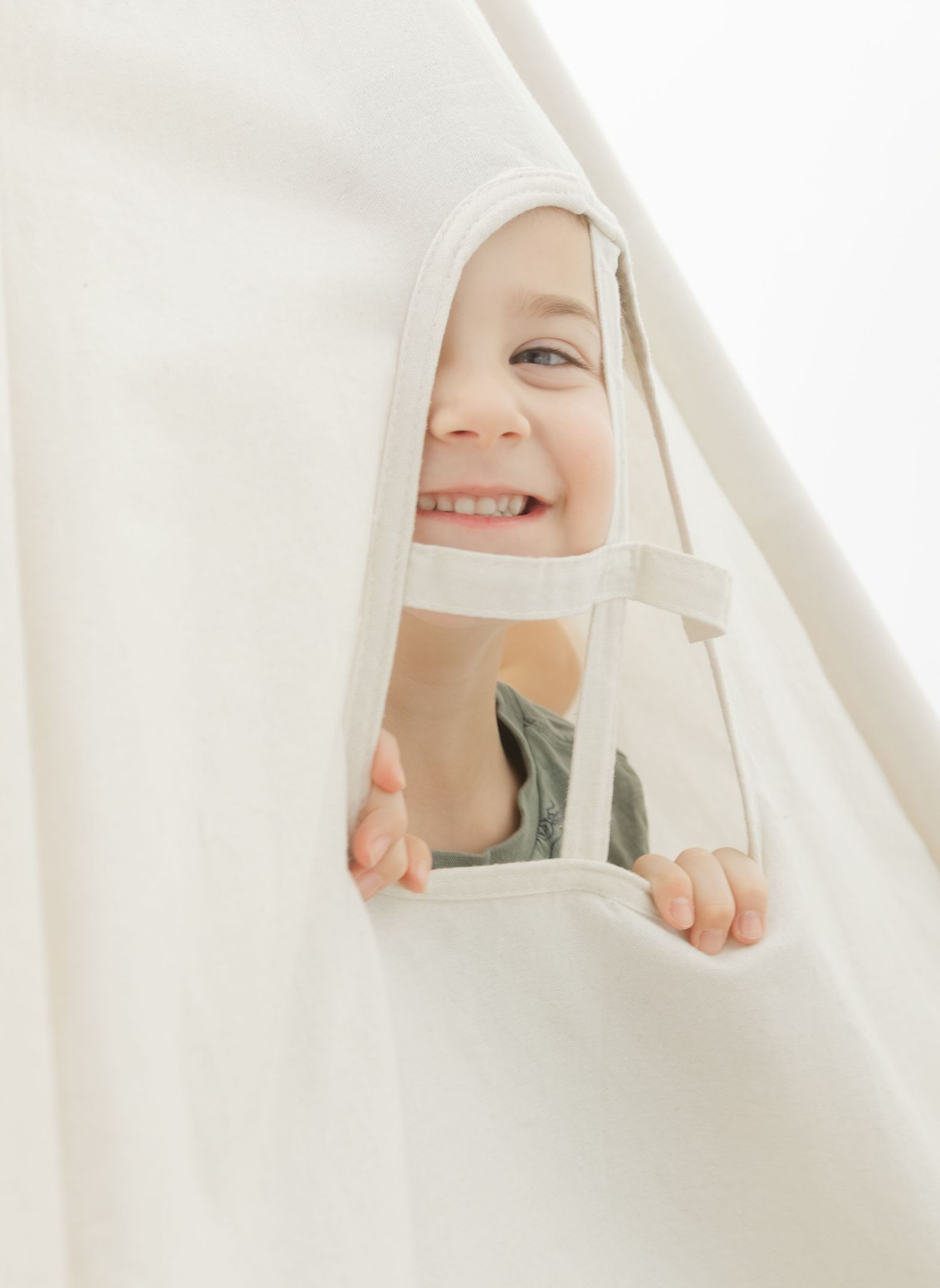 child peeking through curtain laughing candid studio child photography St Albert Alberta