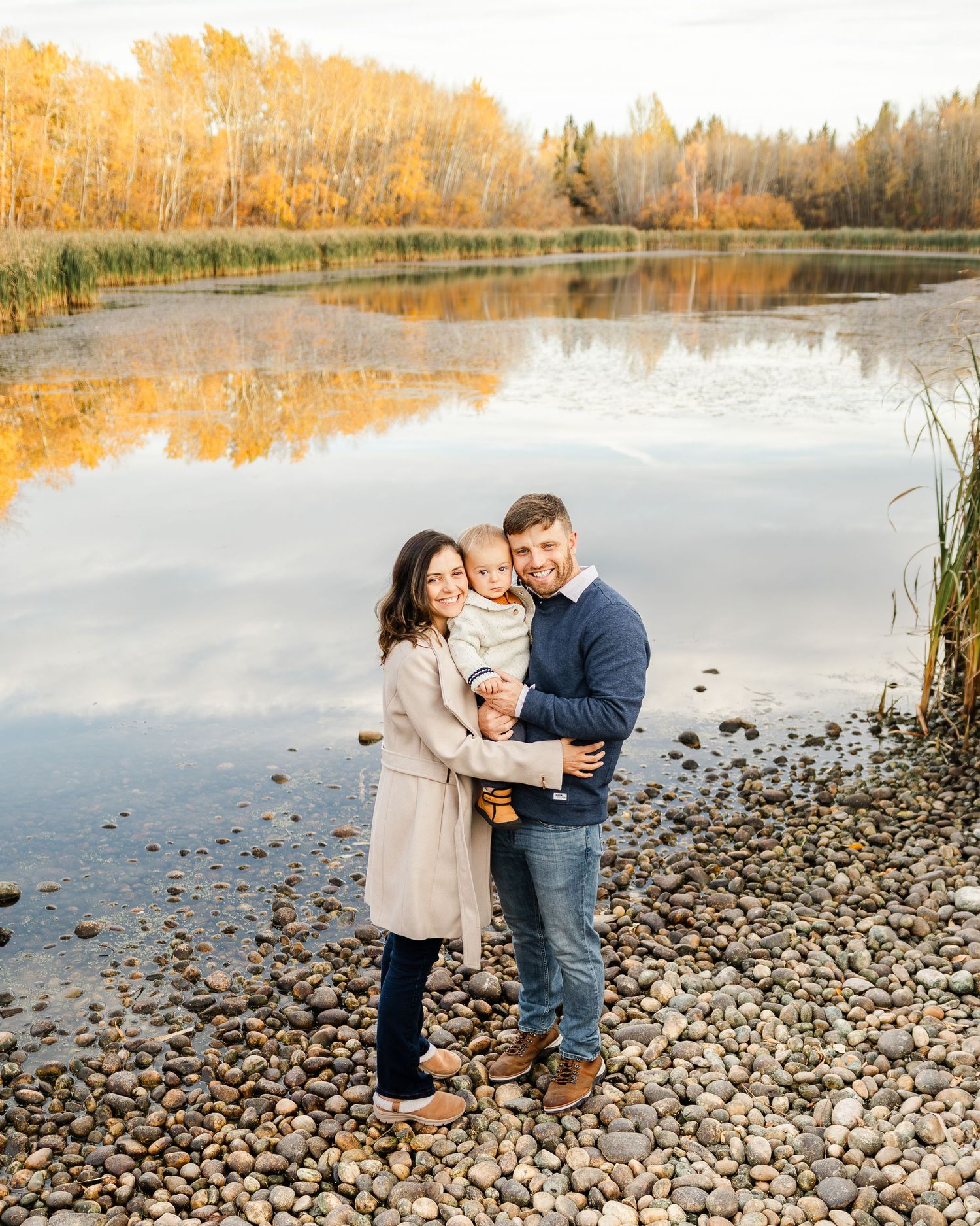 couple standing by lake during outdoor maternity session St Albert photographer