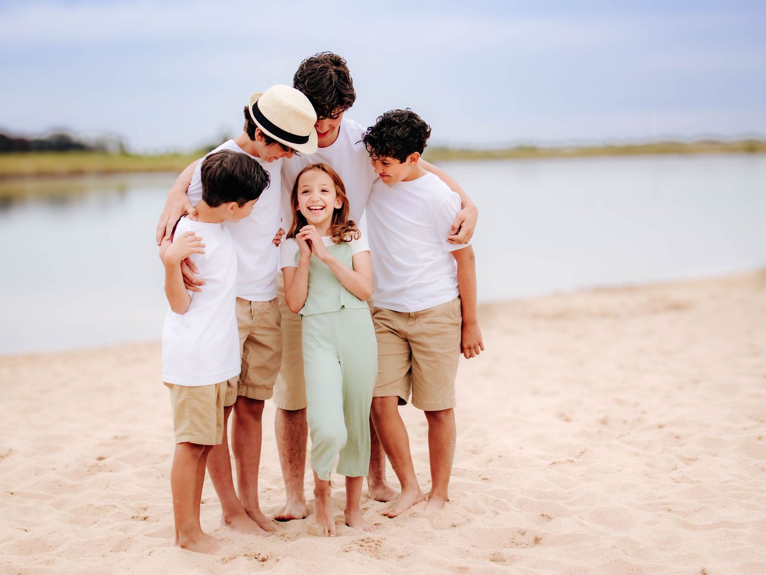 family of five hugging together on sandy beach lifestyle family photography St Albert Alberta