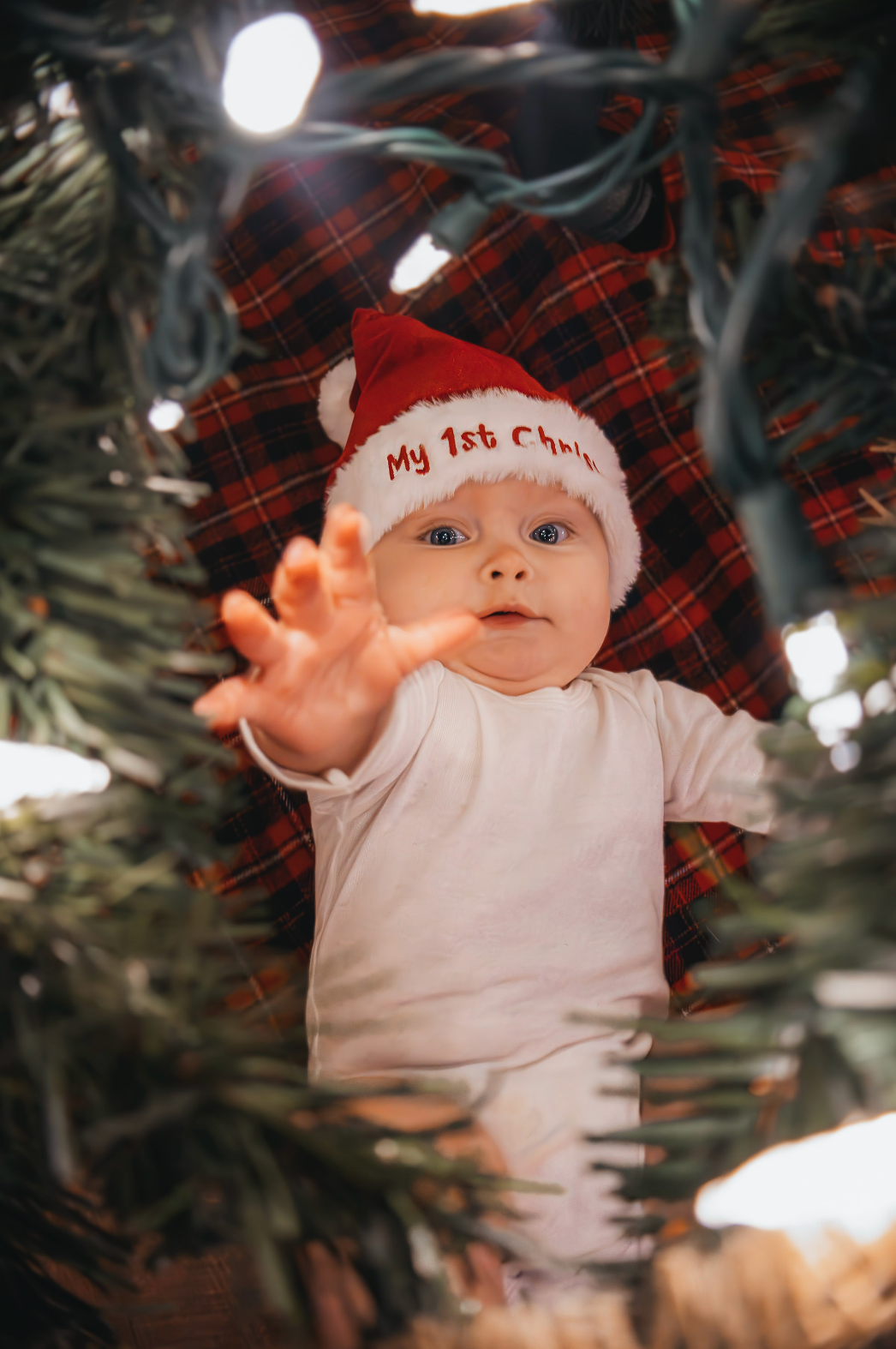Holiday scene with a red plaid pattern and twinkling Christmas lights in soft focus.