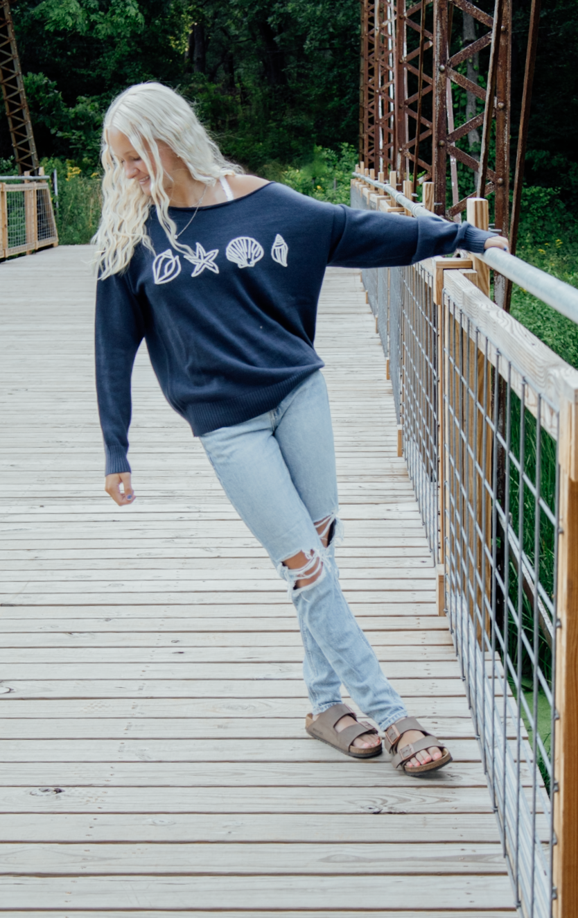 Four sequential photos showing a person walking across a wooden bridge wearing jeans and a navy sweater.