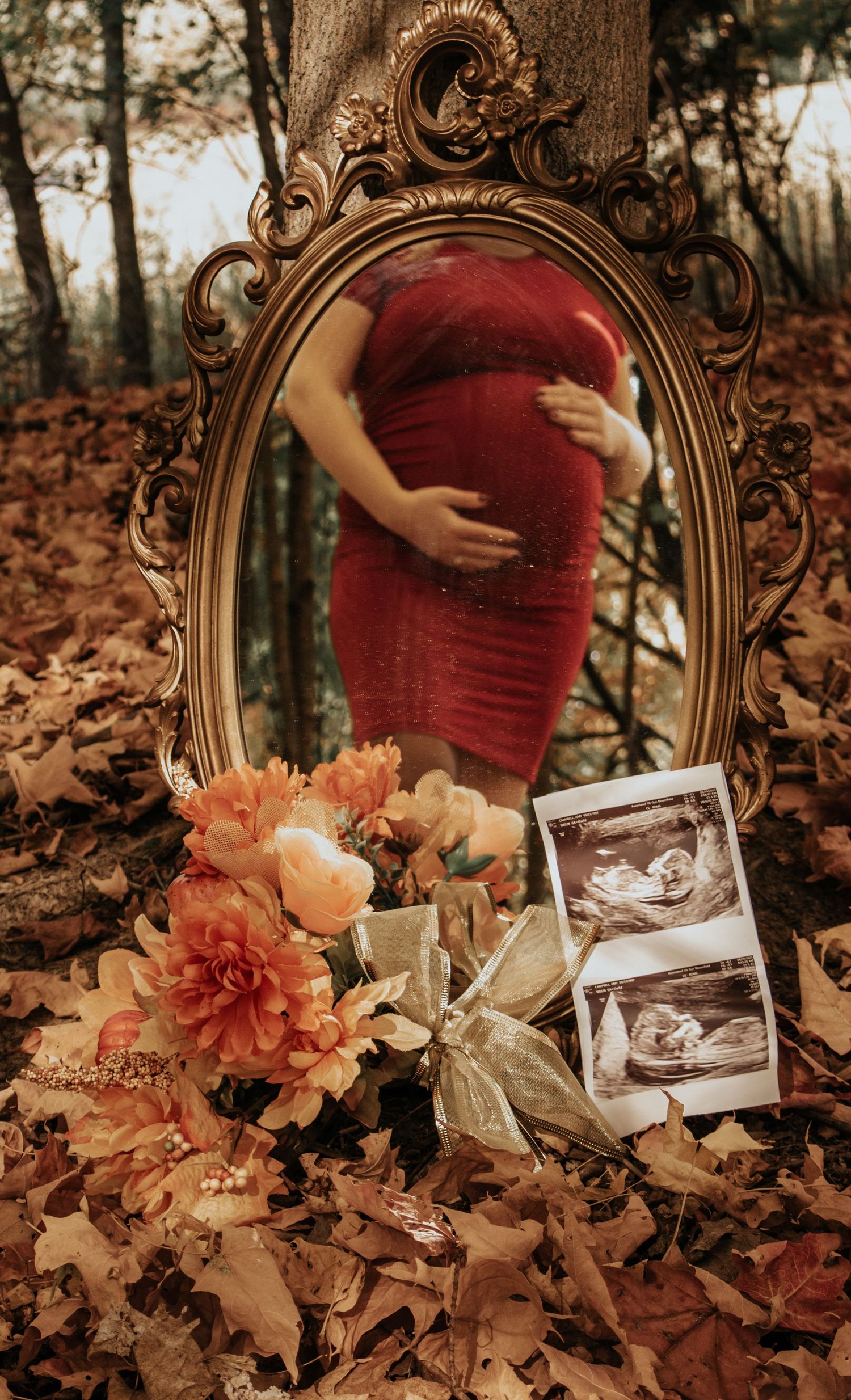 Ornate vintage mirror and fall flowers create a romantic maternity photo setting with autumn leaves.