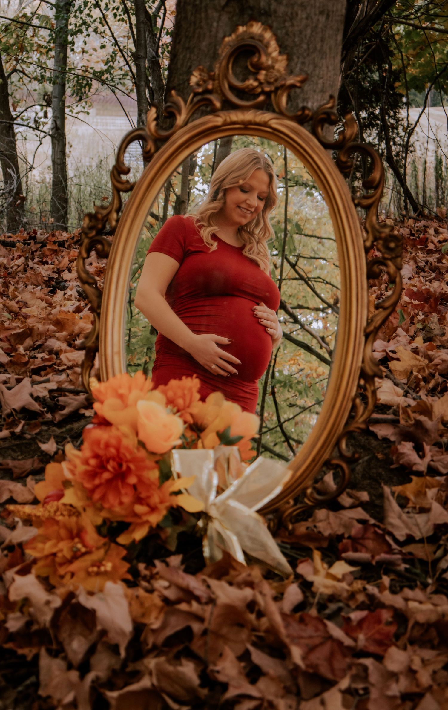 Artistic maternity photos with vintage gold mirror and orange floral arrangements.