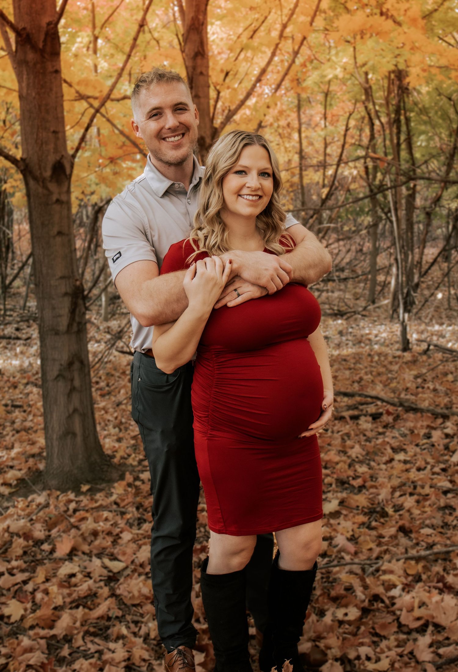 Intimate couple's maternity photos captured in a forest with golden autumn colors.