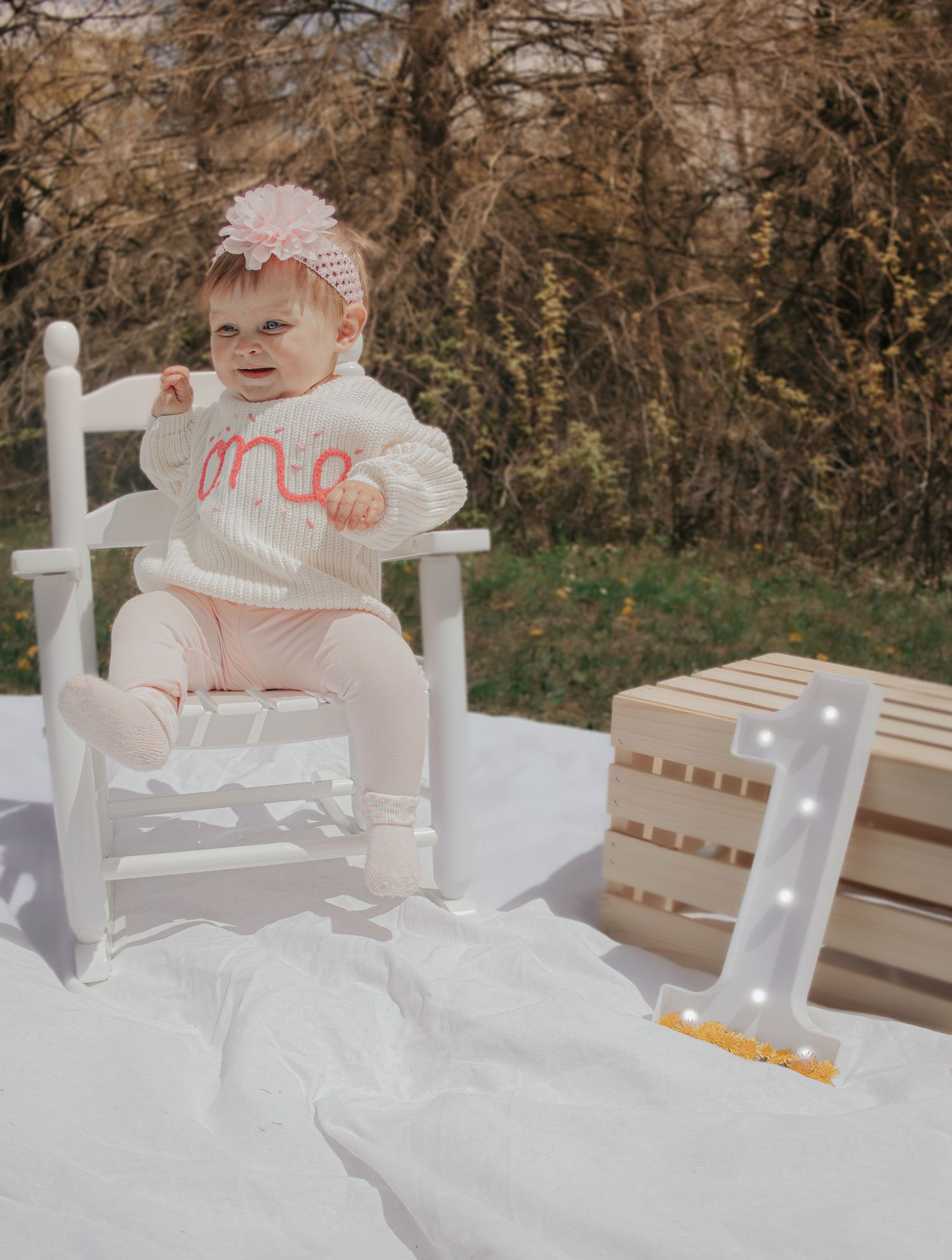 Baby girl in white rocking chair wearing \