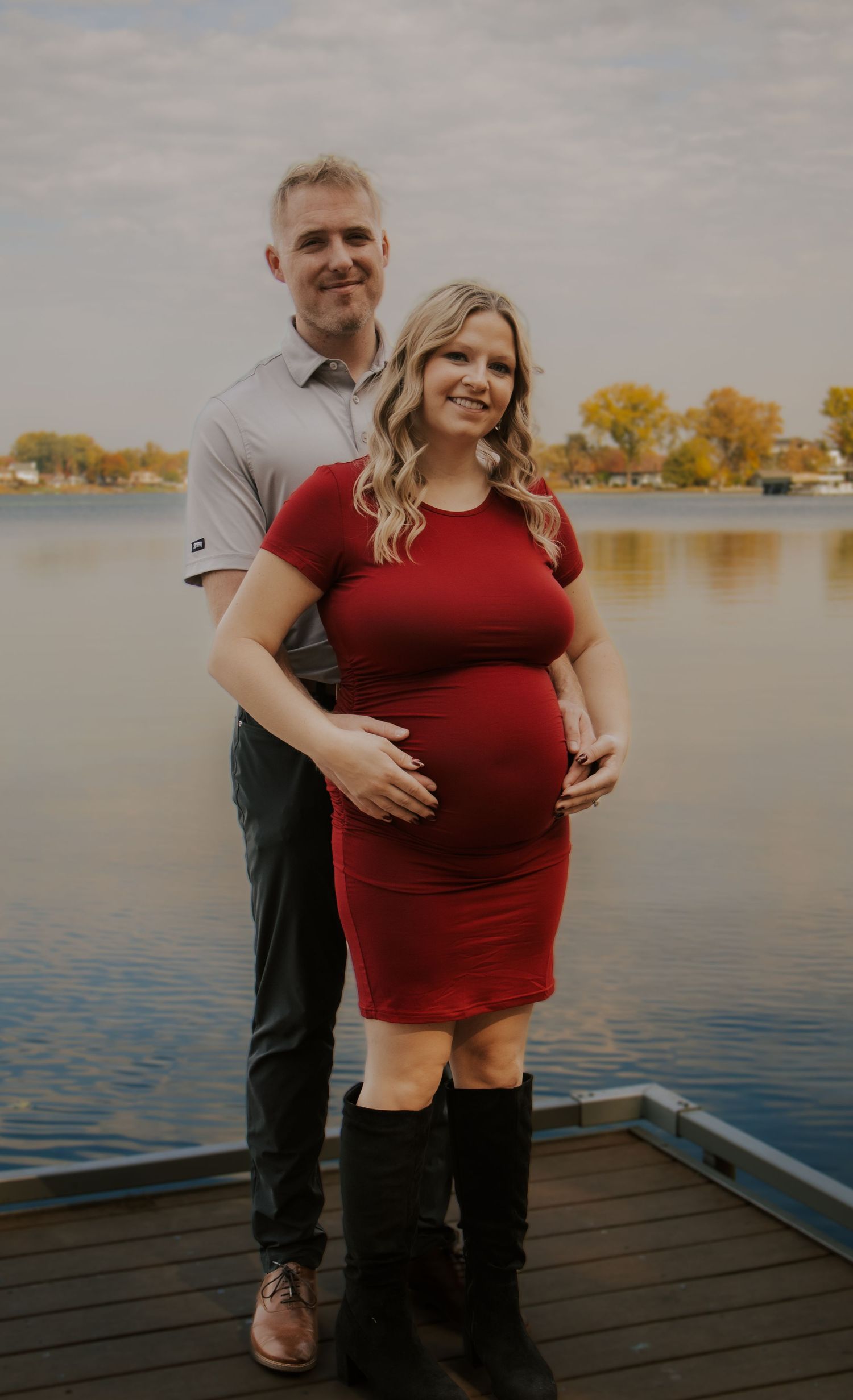 Waterfront maternity session featuring couple on dock during fall season.