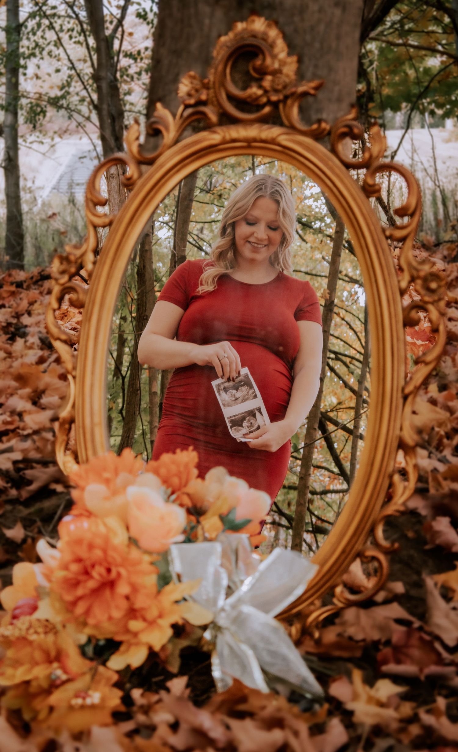 Ornate gold mirror photoshoot with orange flowers and autumn leaves.