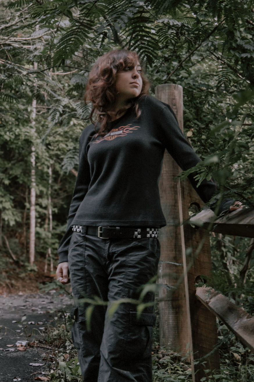 Dynamic forest photoshoot featuring casual black streetwear style among trees and natural scenery.