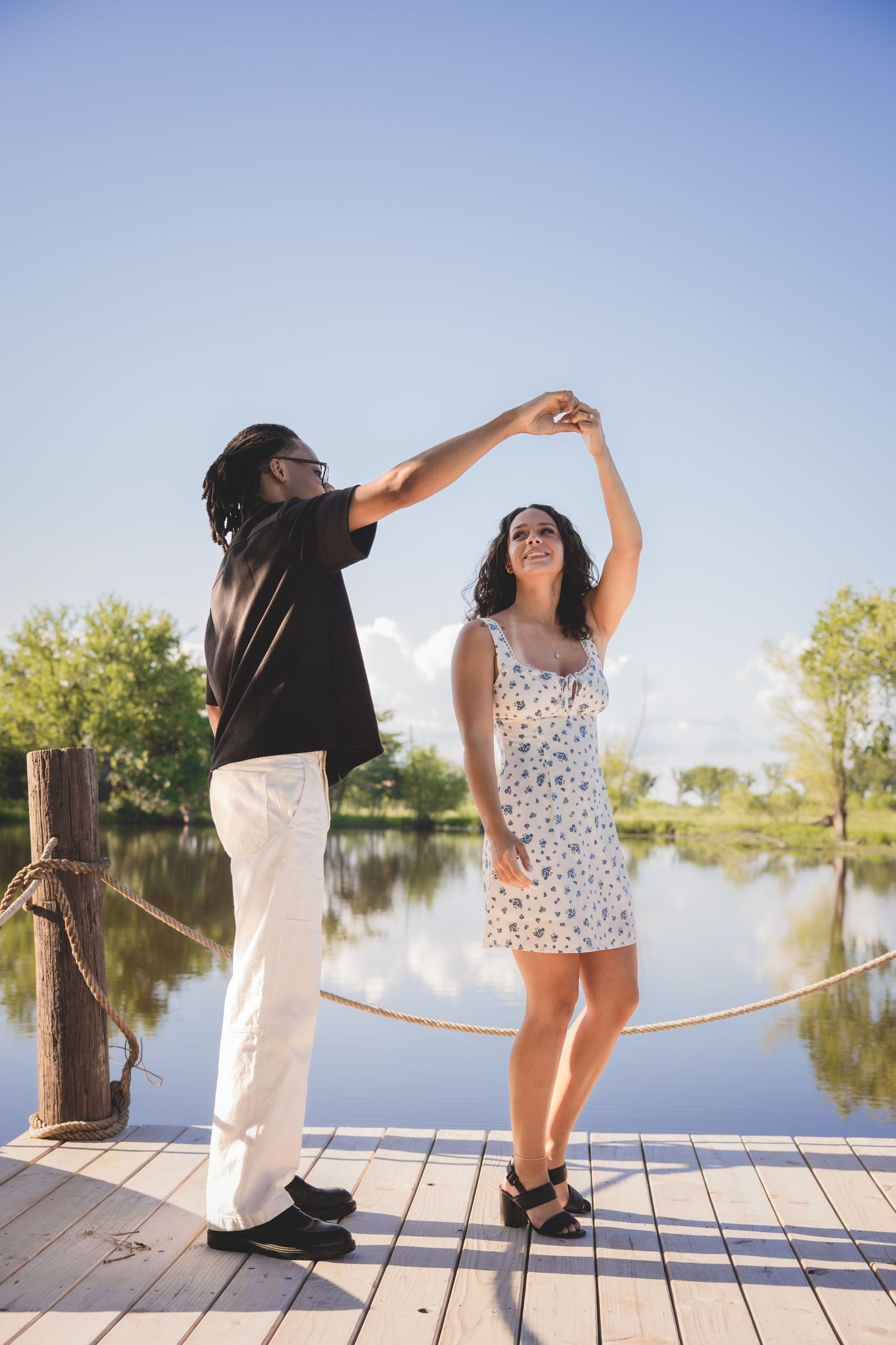couple dancing on a dock near the water