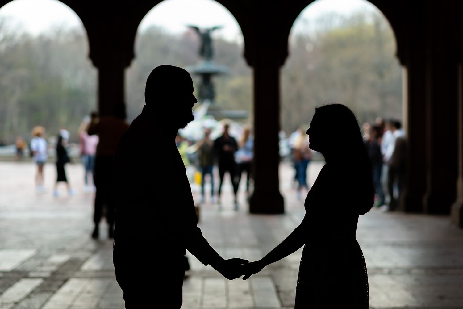 Silhouettes of people standing against white background in artistic composition.