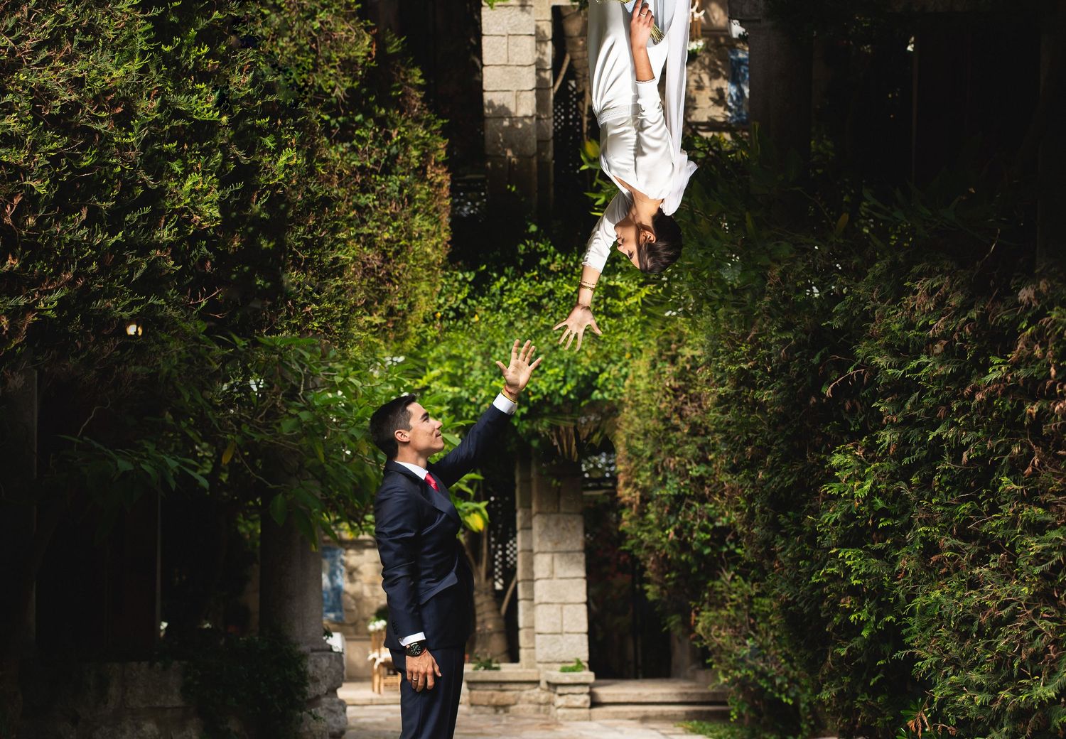 An emotive, creative composite in a garden setting with lush greenery and stone architecture during Spain wedding.