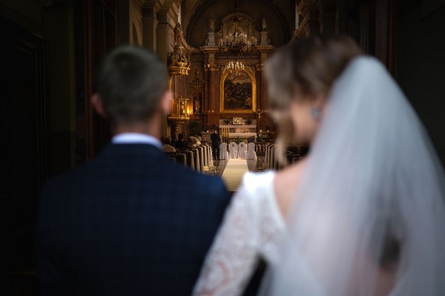 Para młoda w drzwiach czeka na wejście do kościoła.