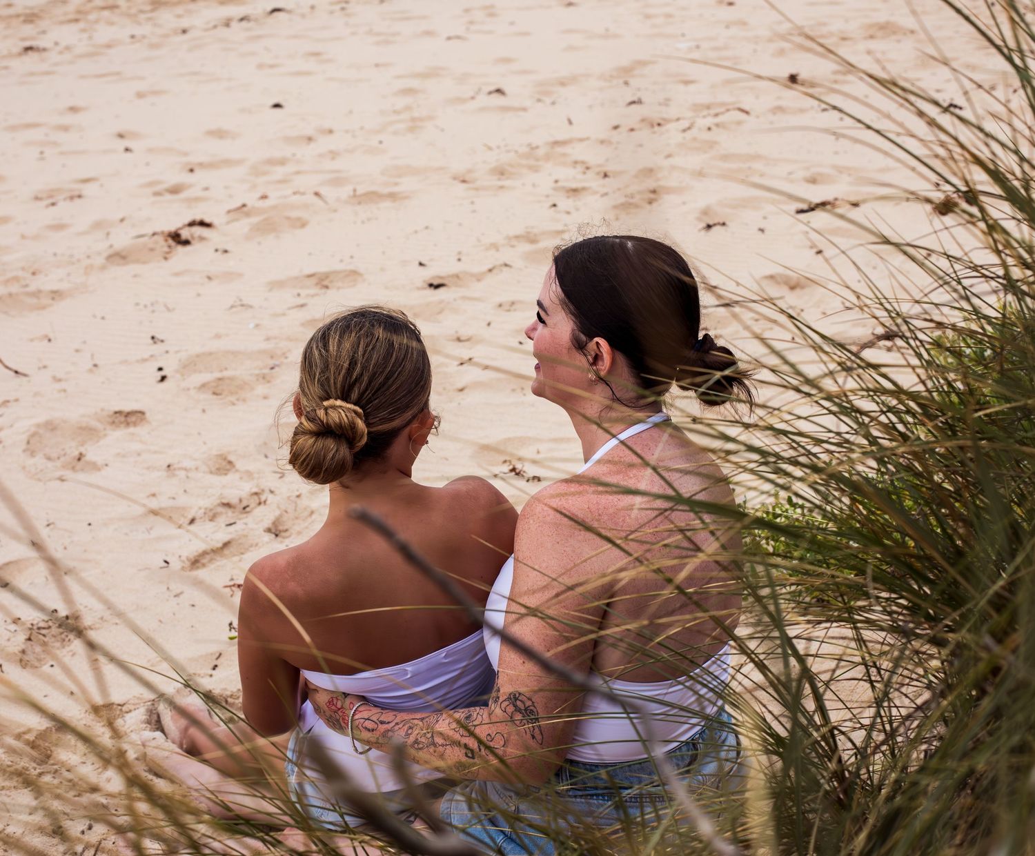 Sweet mother-daughter embrace on grassy headlands during a motherhood session taken by A Lasting Impression Photography.