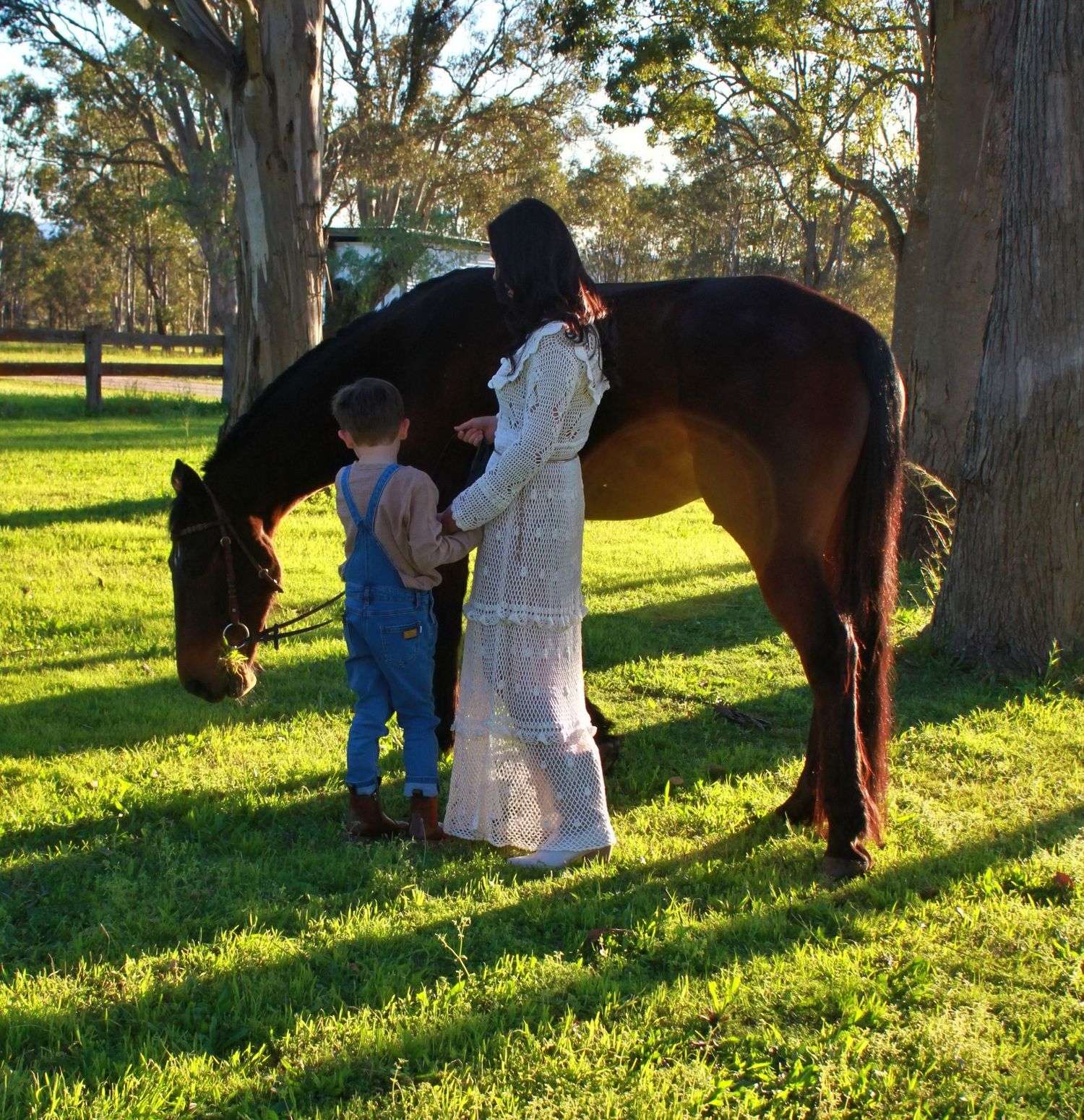 Mother and son gently interacting with a horse outdoors during a family session