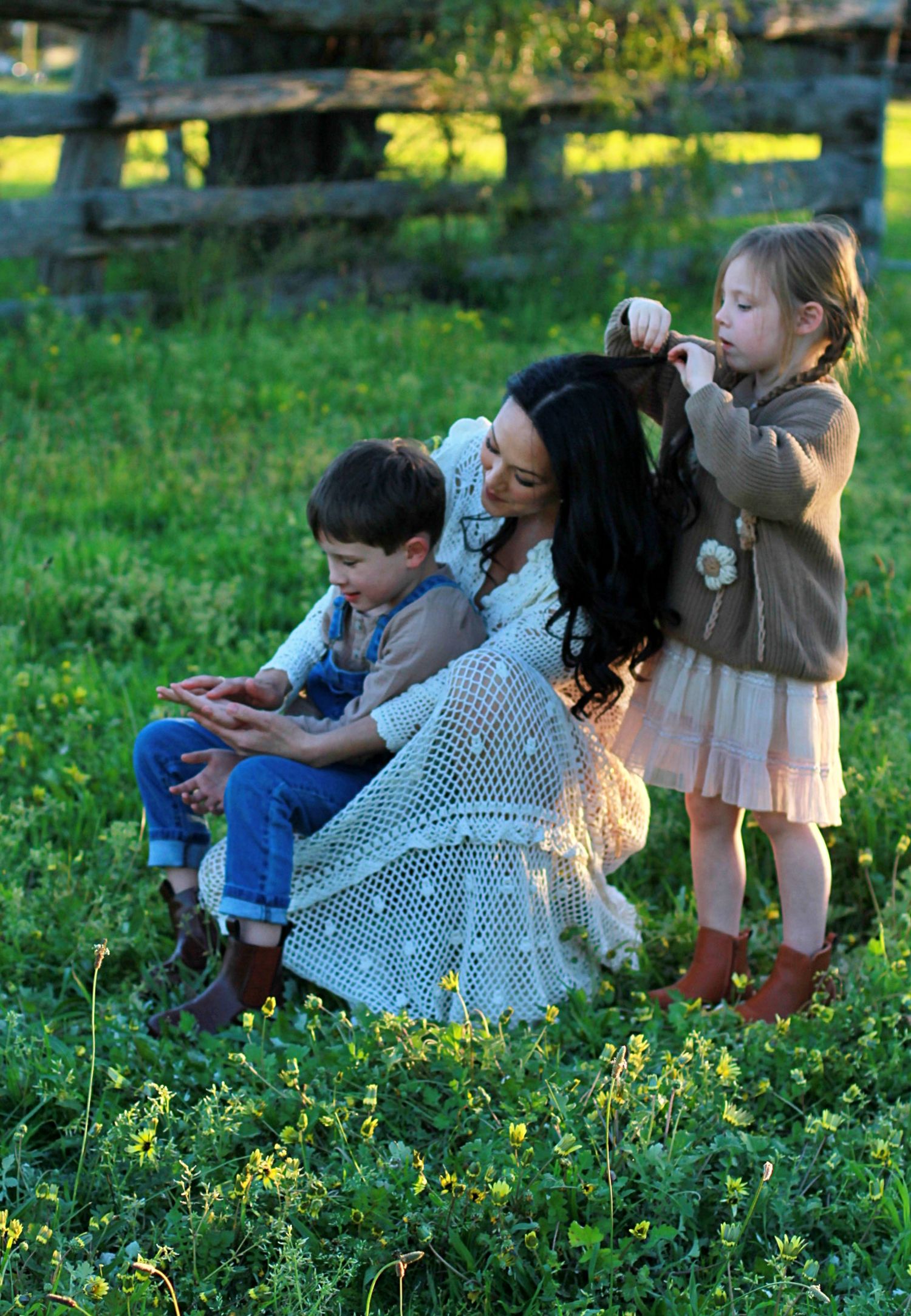 Relaxed family photo of mum and children sitting together outdoors during a family session