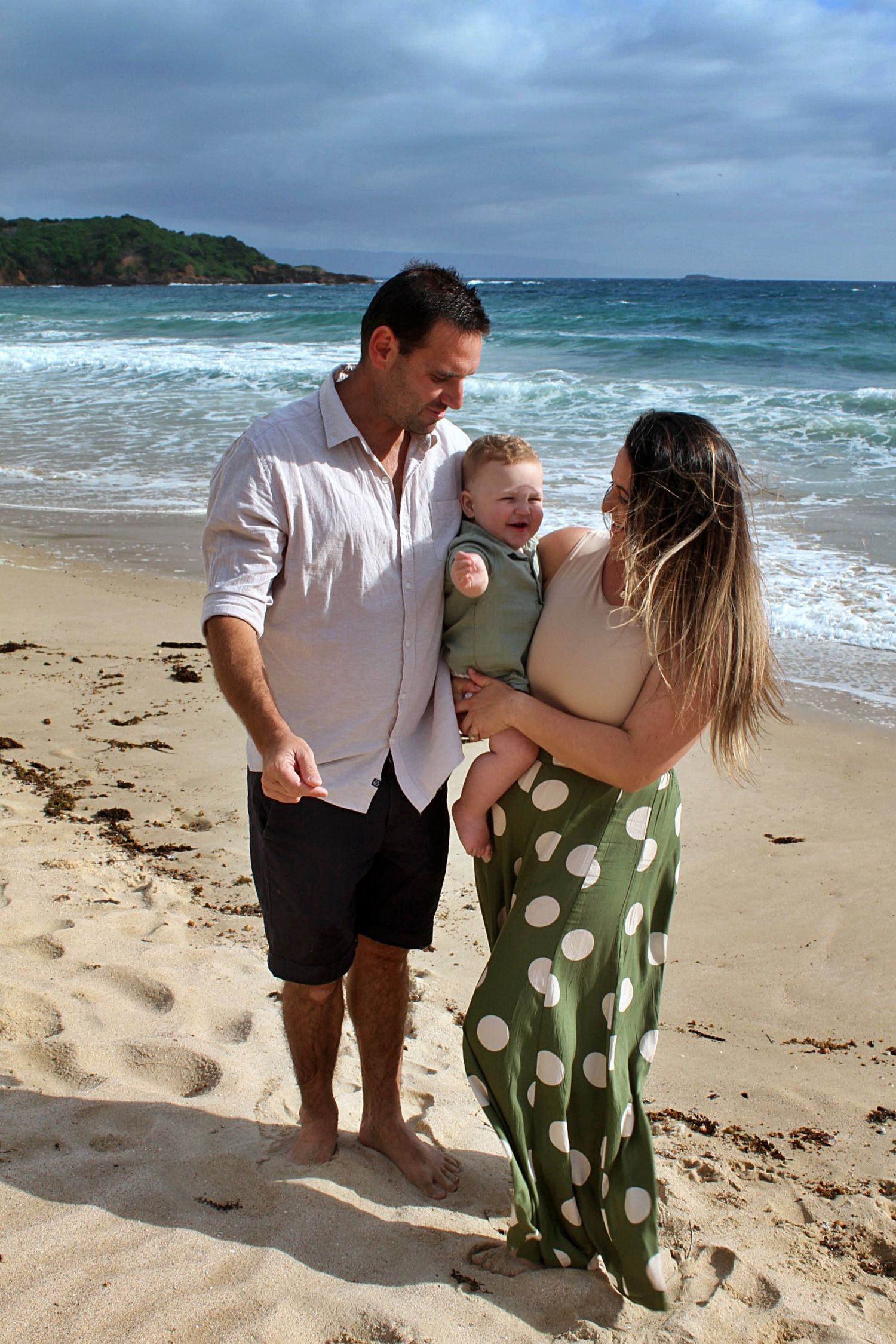 A natural family moment of mum and dad with their son on the beach in the Illawarra.