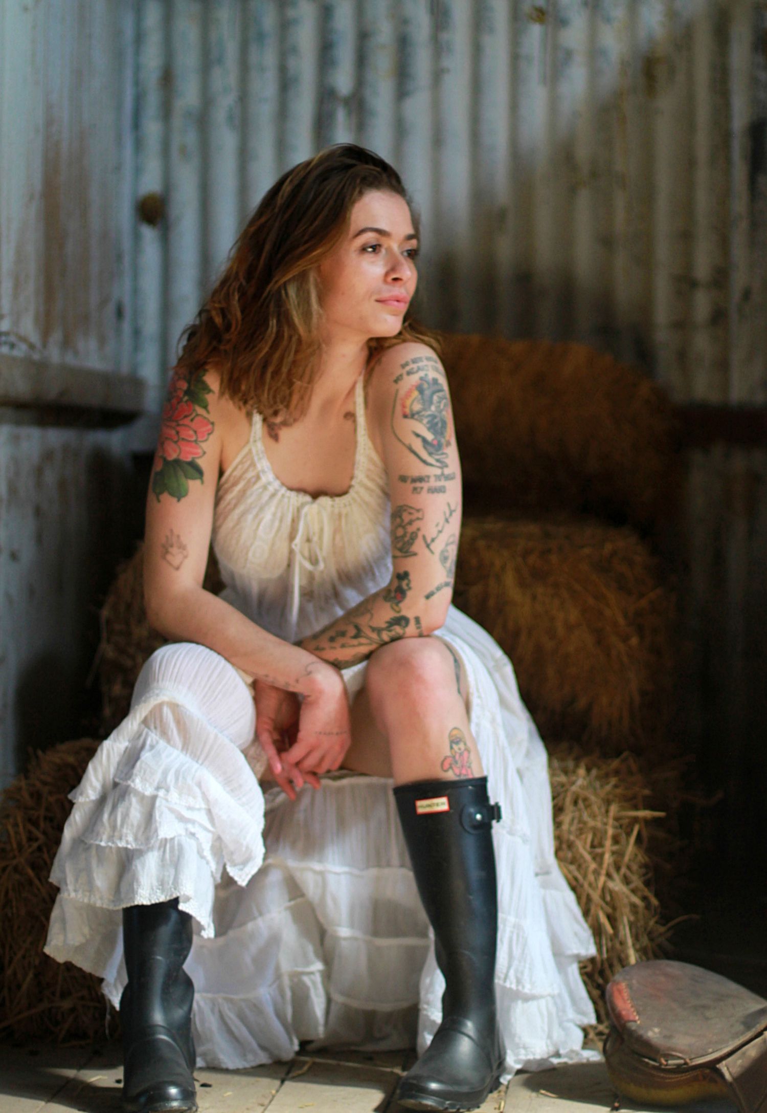 Solo portrait of women sitting on barns looking off to the side