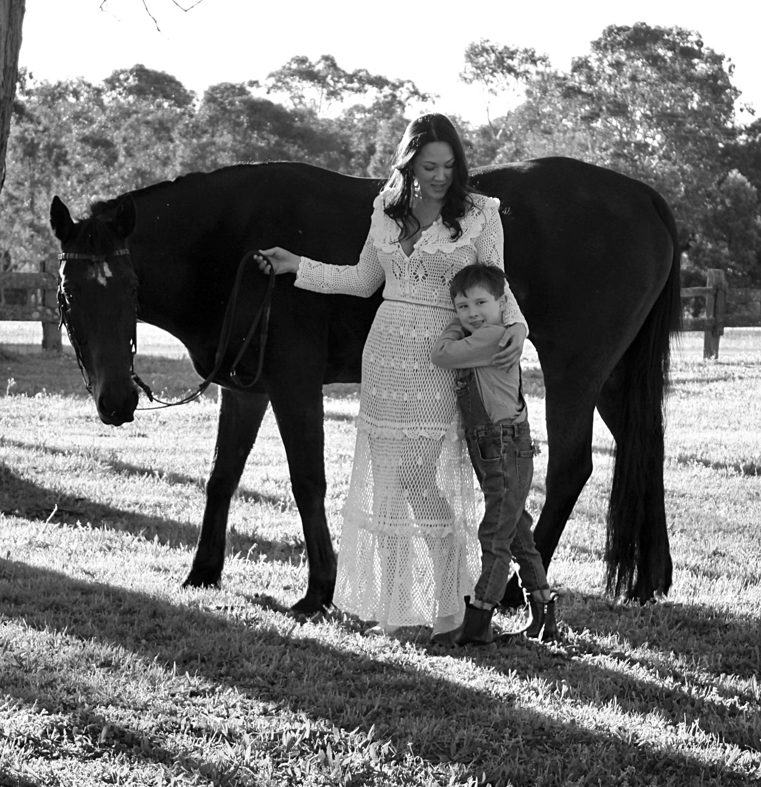 Mother and son gently interacting with a horse outdoors during a family session