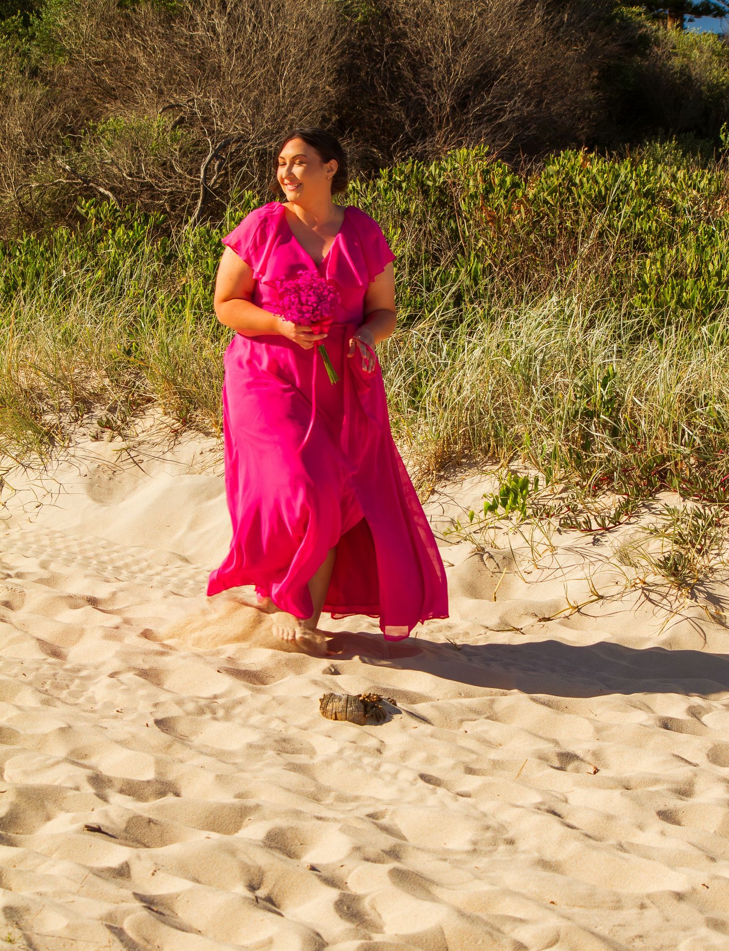 Bridesmaid walking down the aisle at a beach wedding ceremony, elegant moment before the bride’s entrance.