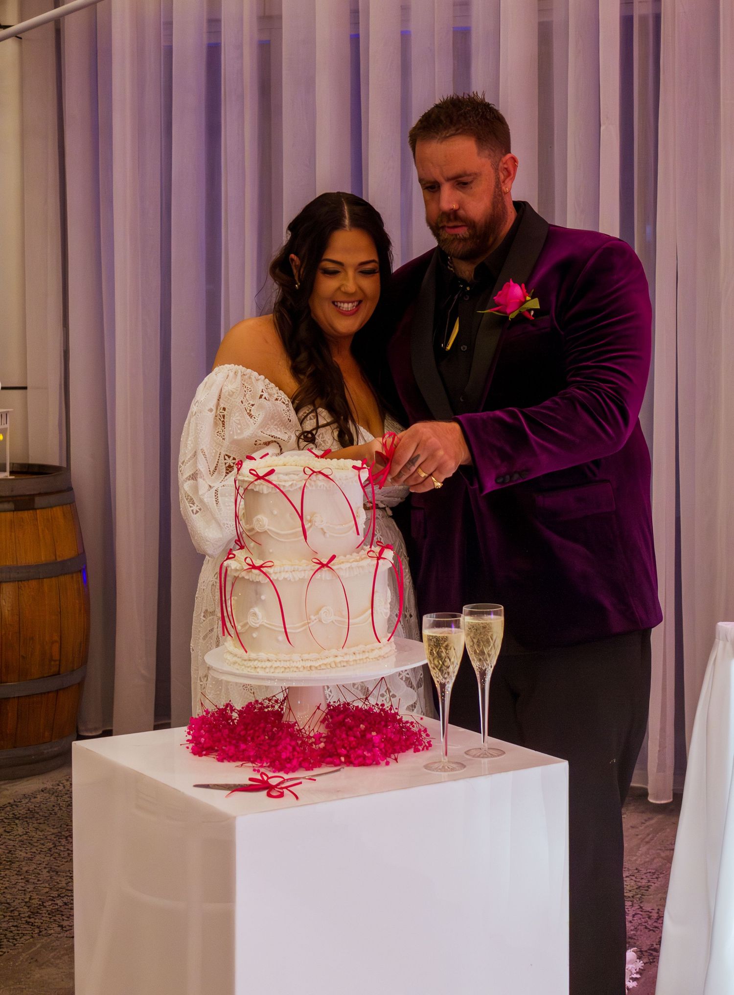 Bride and groom cutting their wedding cake together during the reception celebration.