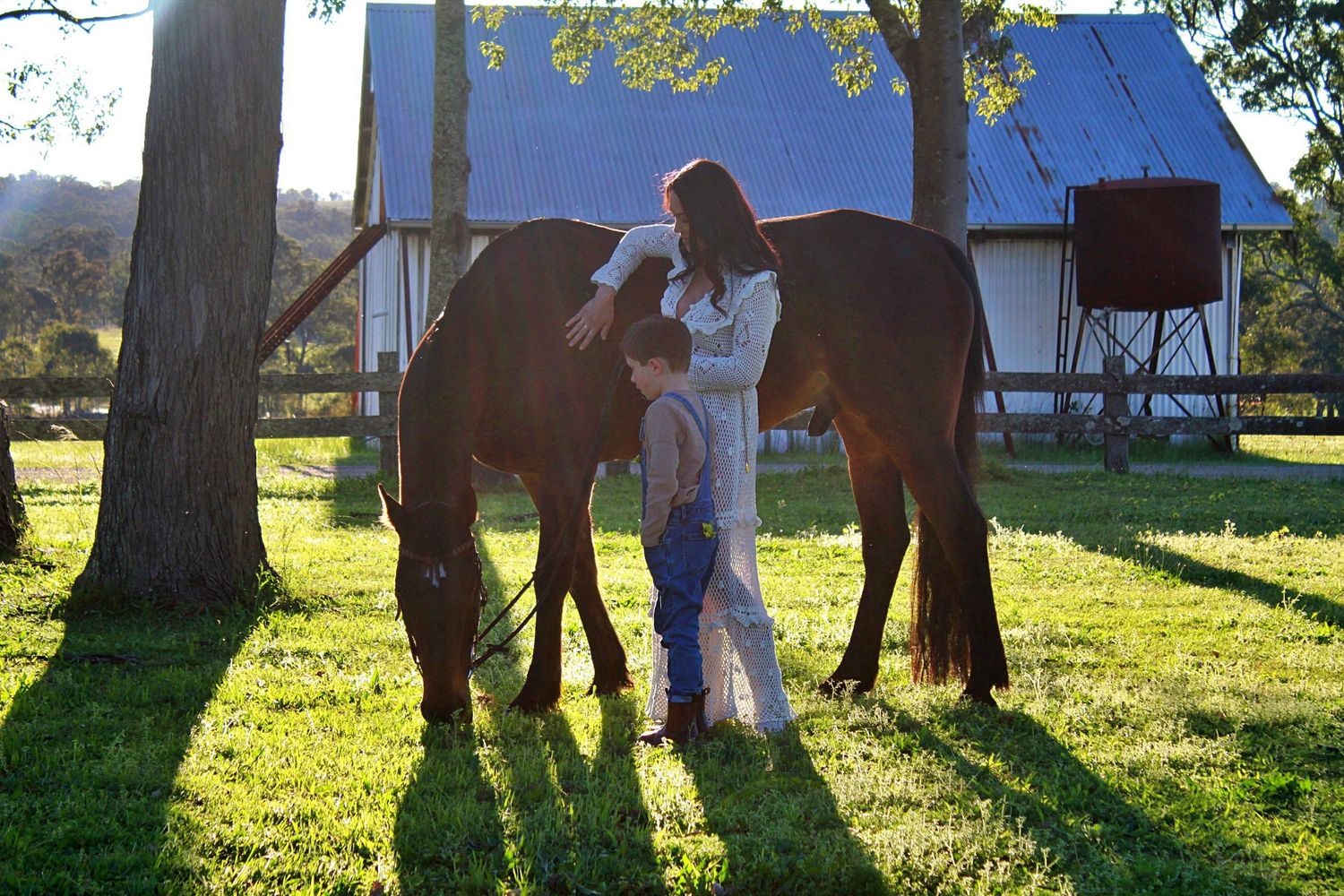 Mother and son gently interacting with a horse outdoors during a family session