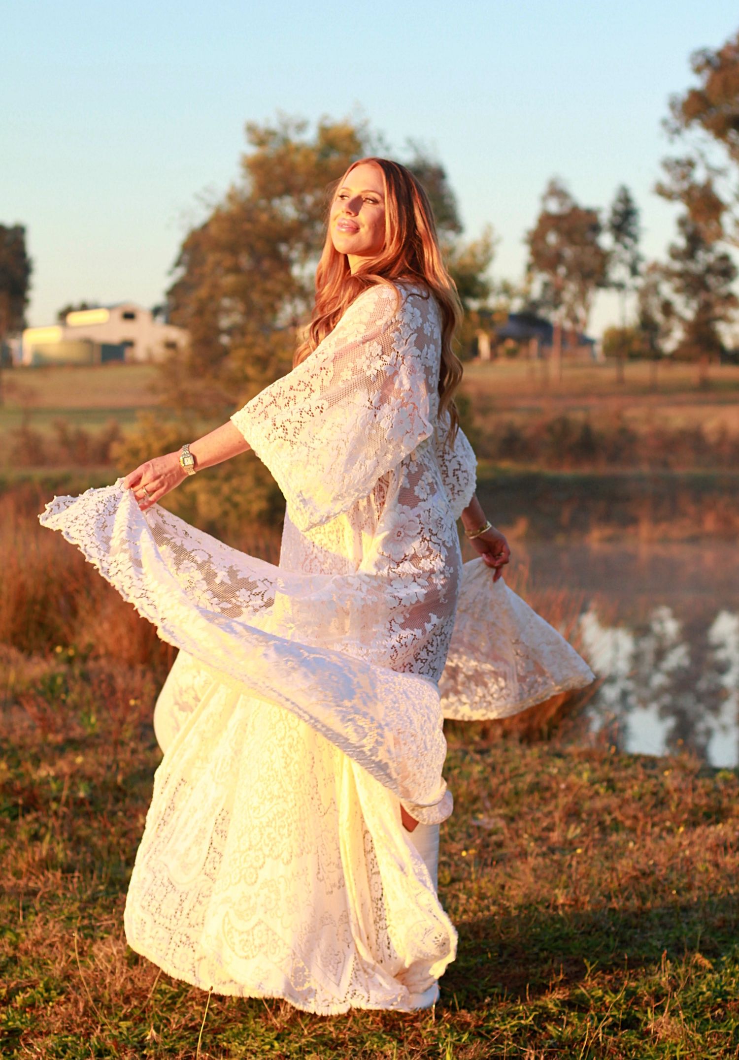 Pregnant woman enjoying a sunrise maternity photoshoot, spinning her dress.